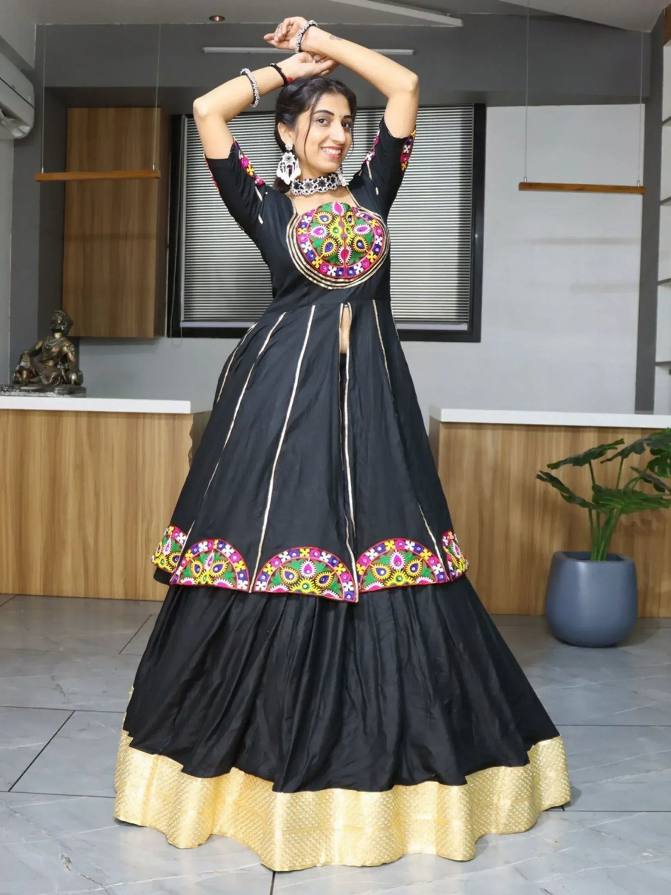 Black ethnic gown with colorful embroidery and gold border, perfect for Indian celebrations