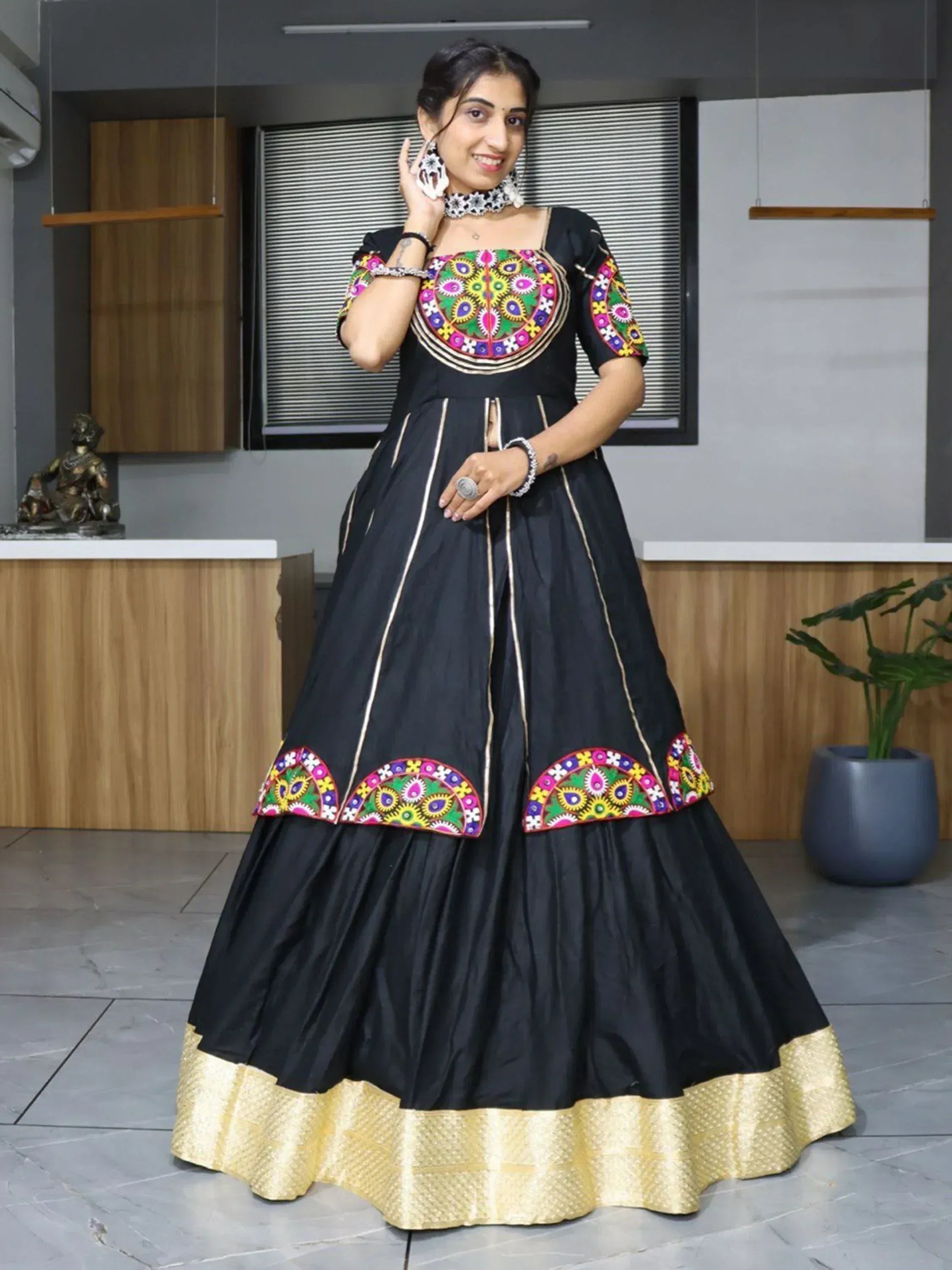 Black ethnic gown with colorful embroidery and gold border, perfect for Indian festive occasions