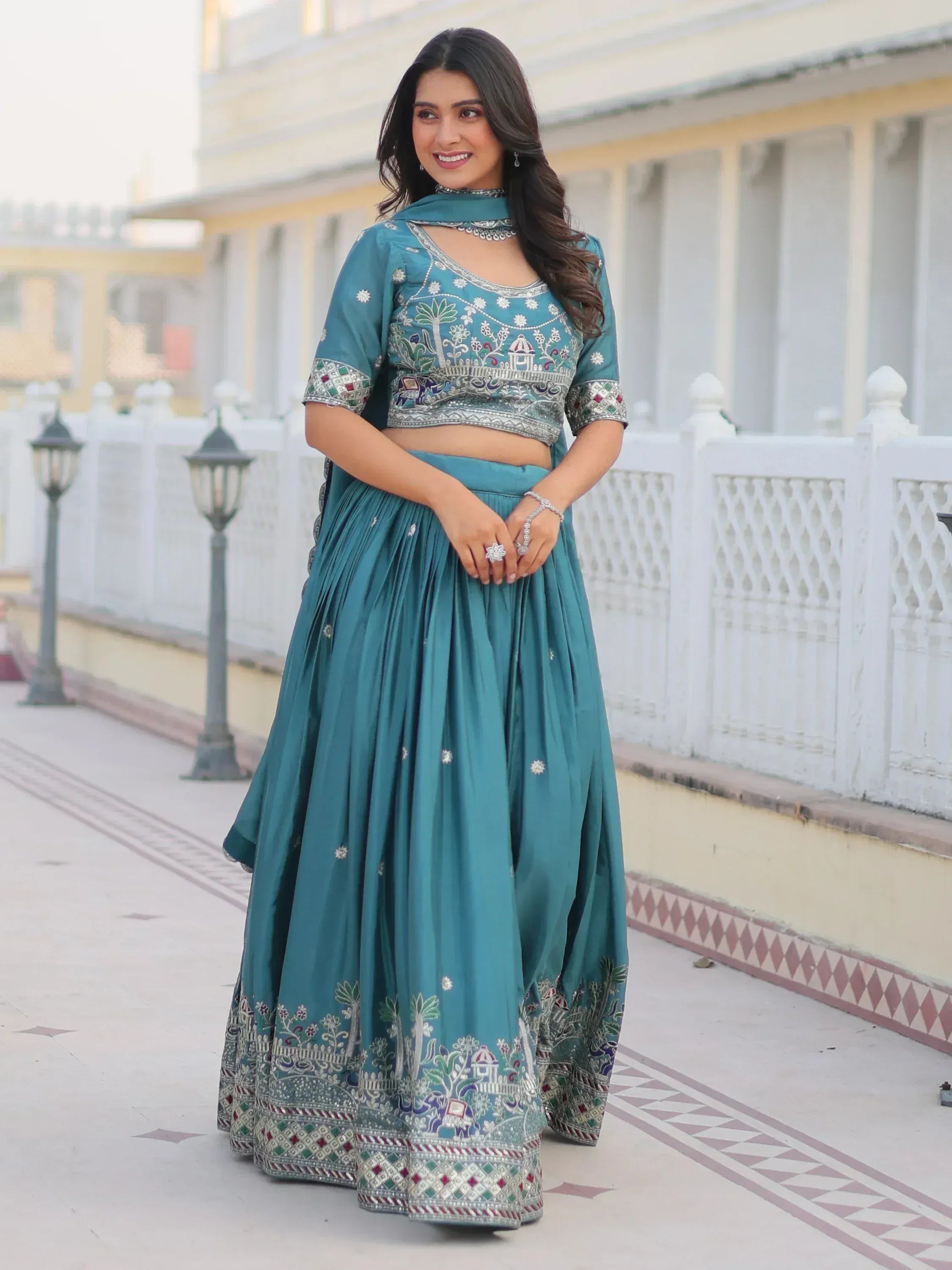 Teal embroidered lehenga choli with floral and elephant motifs, perfect for Indian ethnic wear occasions.