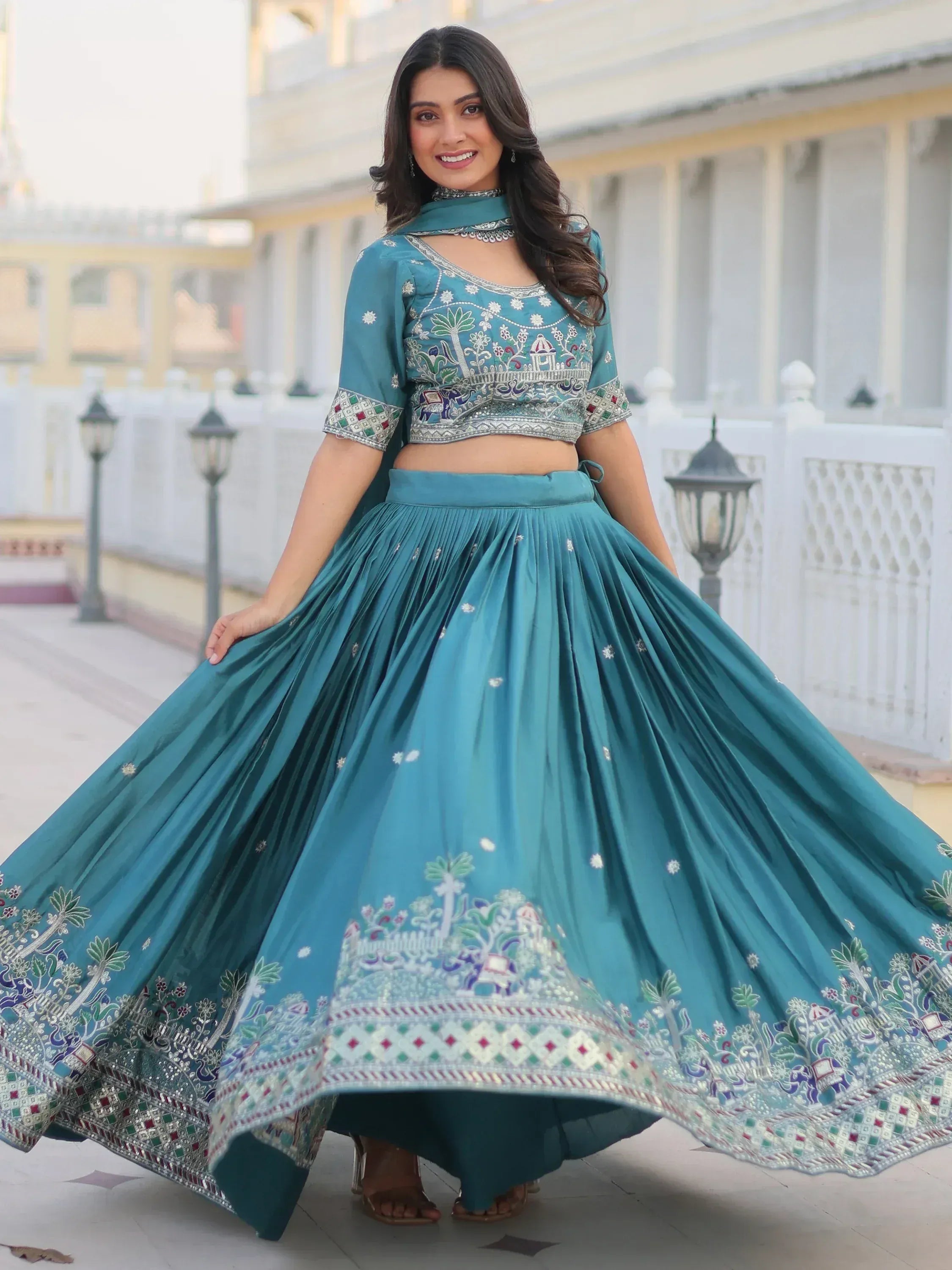 Teal embroidered lehenga choli with floral and elephant motifs, perfect for Indian ethnic wear occasions.