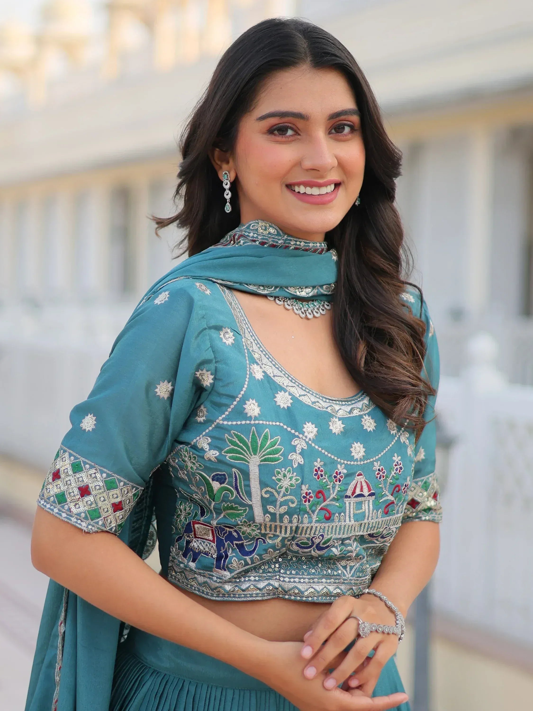 Teal embroidered ethnic blouse with elephant and palm tree motifs, paired with matching dupatta for Indian wear