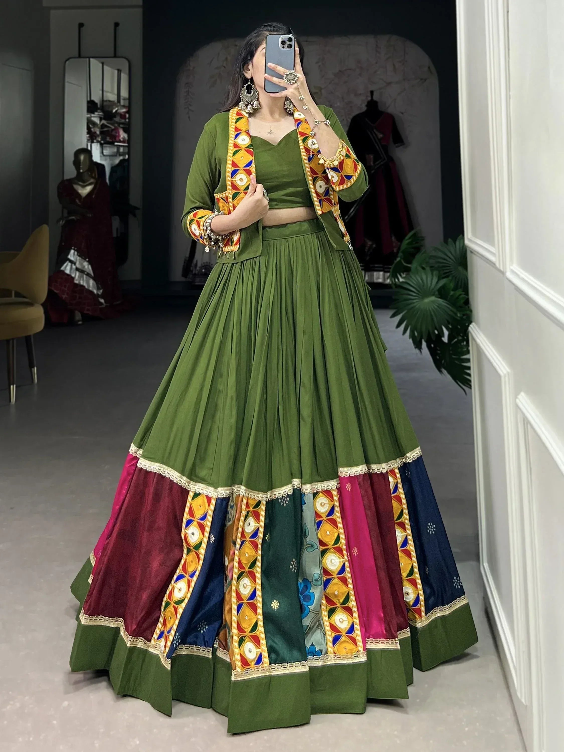 Green Indian lehenga choli with colorful mirror work and embroidered border, perfect for festive occasions.