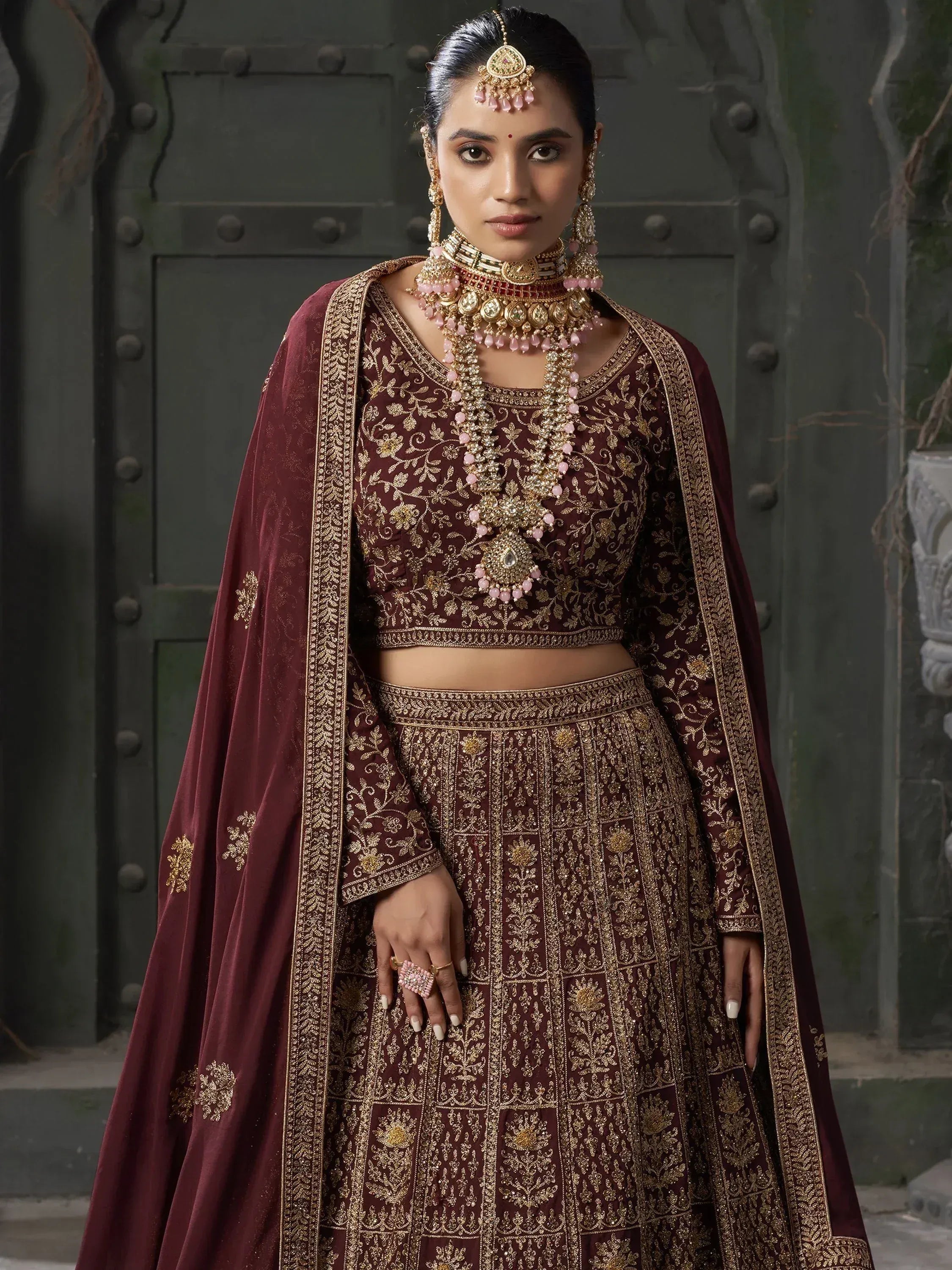 Maroon designer lehenga choli with gold embroidery, perfect for Indian weddings and festive occasions.
