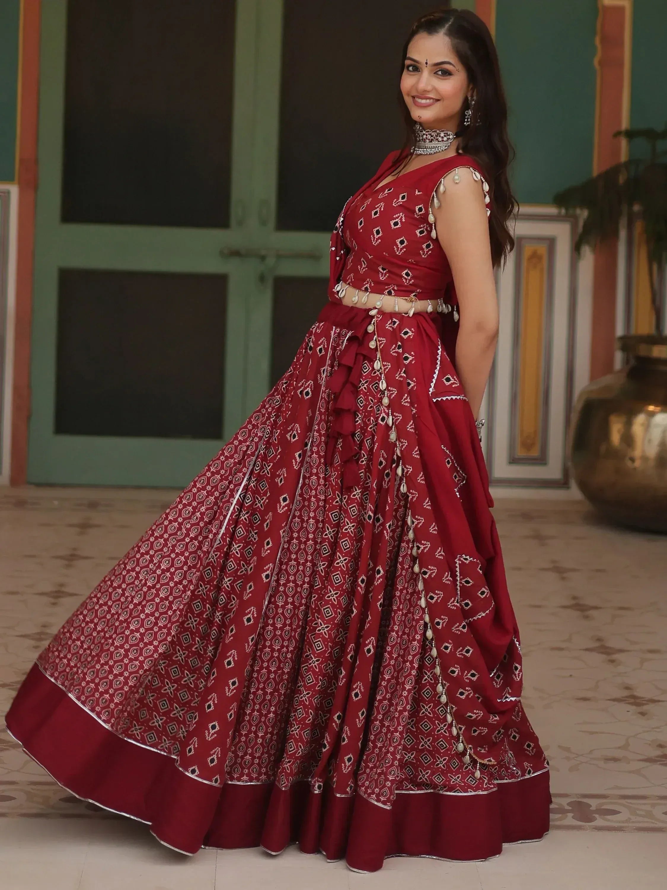 Red printed lehenga choli with pearl embellishments, perfect for Indian ethnic wear occasions
