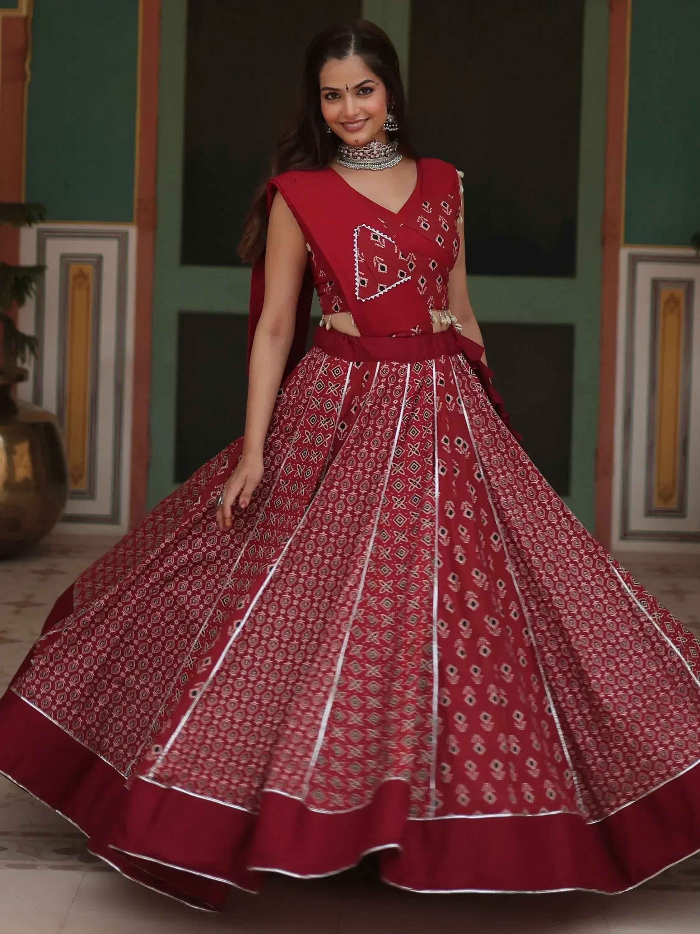 Red embroidered lehenga choli with geometric patterns and silver trim, perfect for Indian ethnic wear.