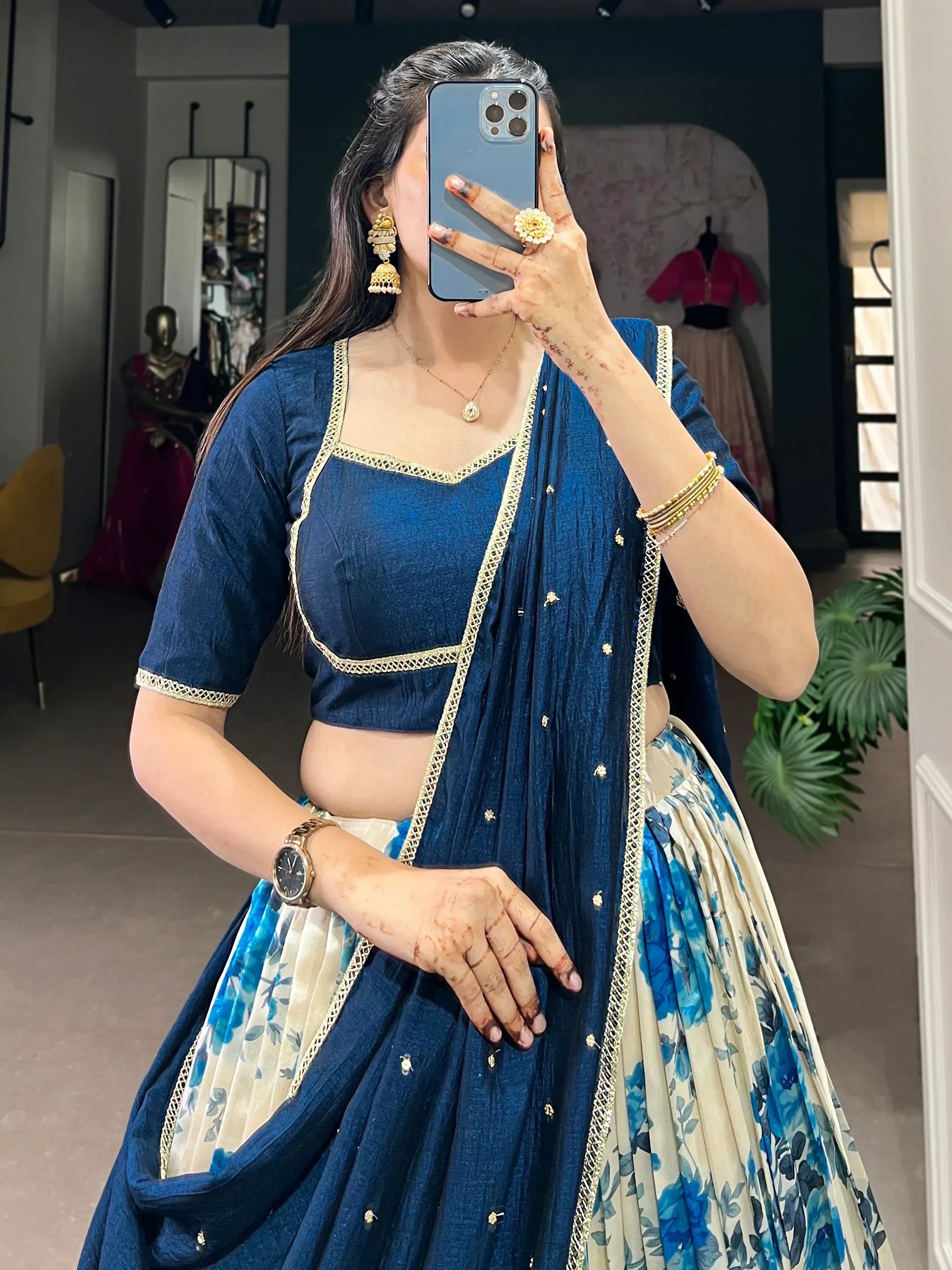 Blue lehenga choli with gold trim, floral skirt, and traditional jewelry for Indian ethnic wear