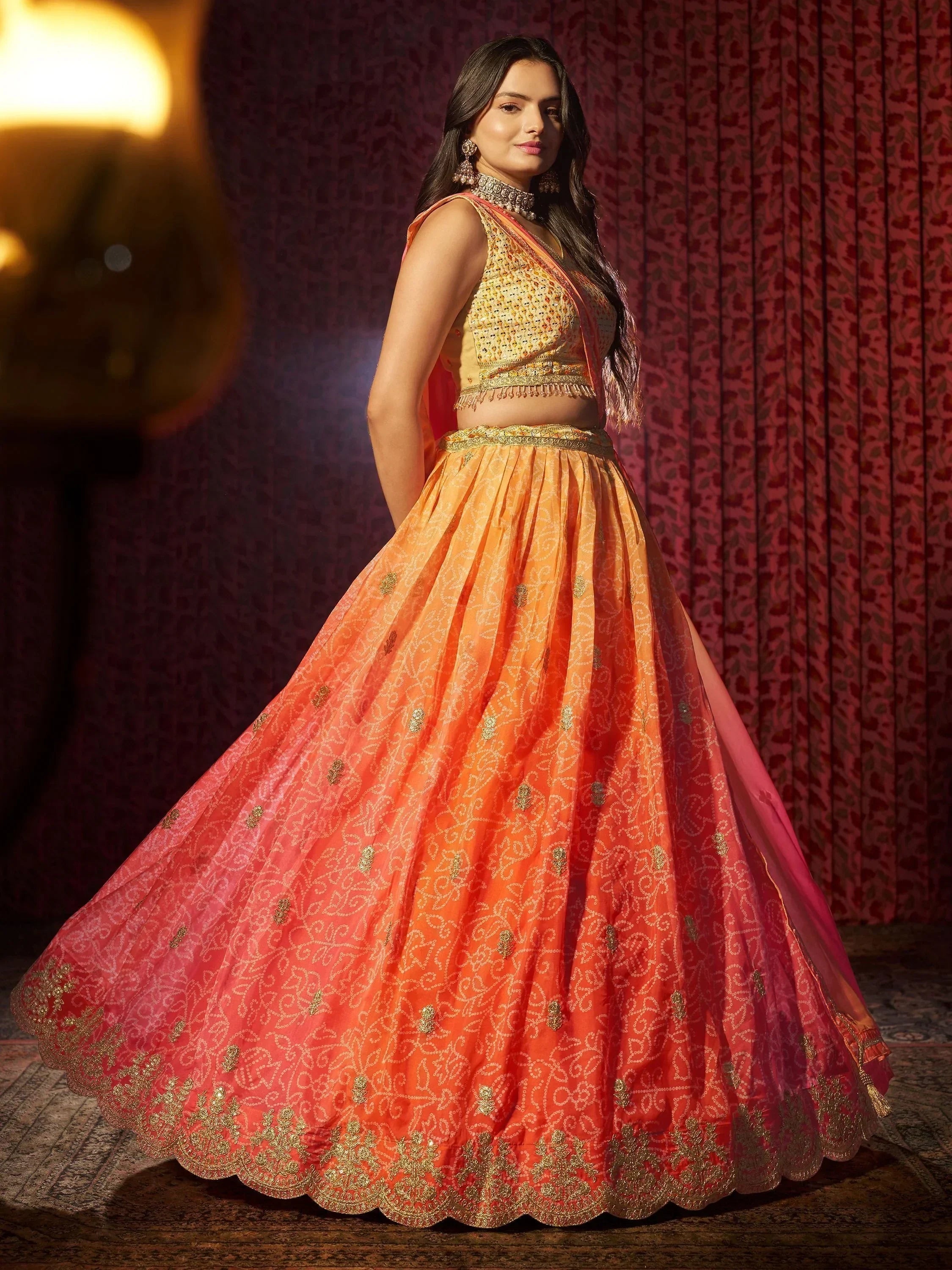 Orange and gold embroidered lehenga choli with intricate detailing, perfect for Indian ethnic wear events.