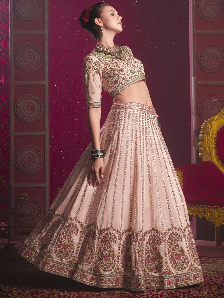 Elegant blush pink lehenga choli with floral embroidery and sequin detailing, perfect for Indian weddings and festive occasions.