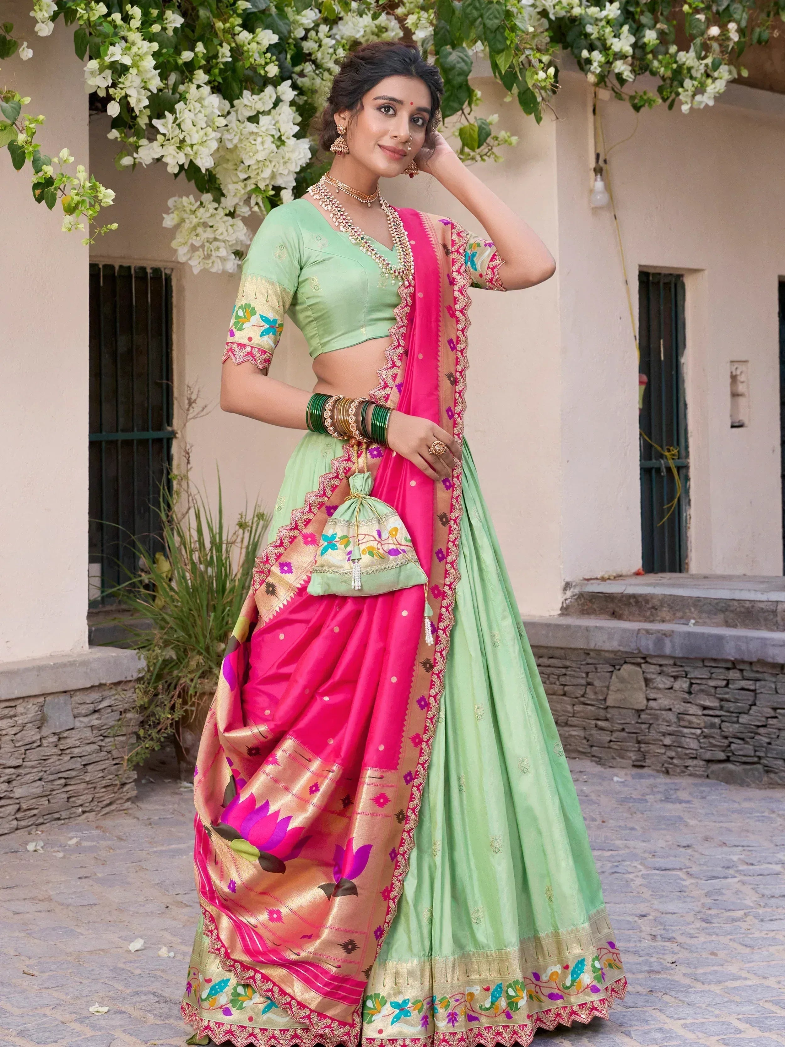 Woman in mint green and pink embroidered lehenga choli with floral dupatta, traditional Indian ethnic wear