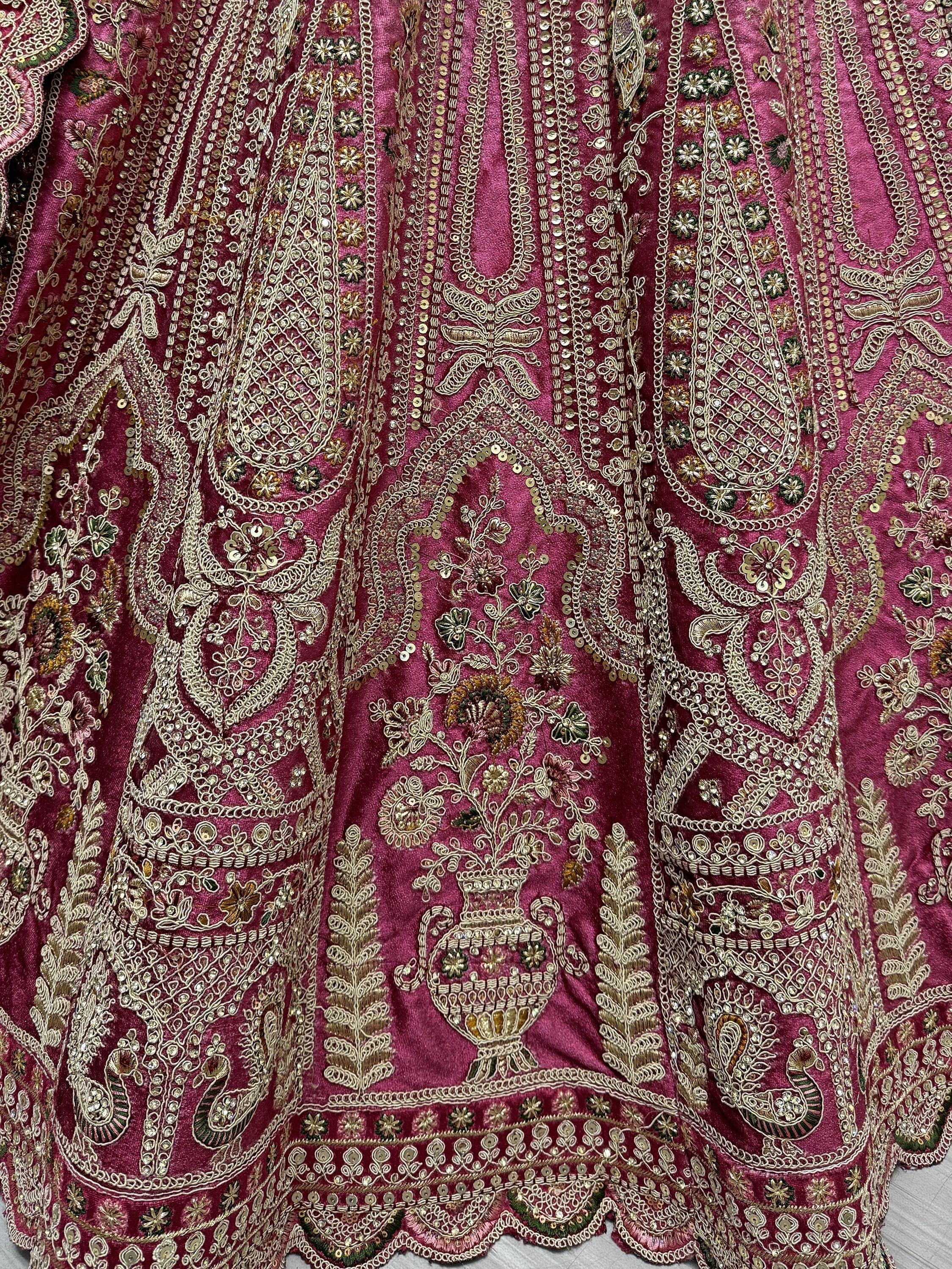Richly embroidered pink Indian ethnic wear with gold paisley and floral motifs, perfect for festive occasions.