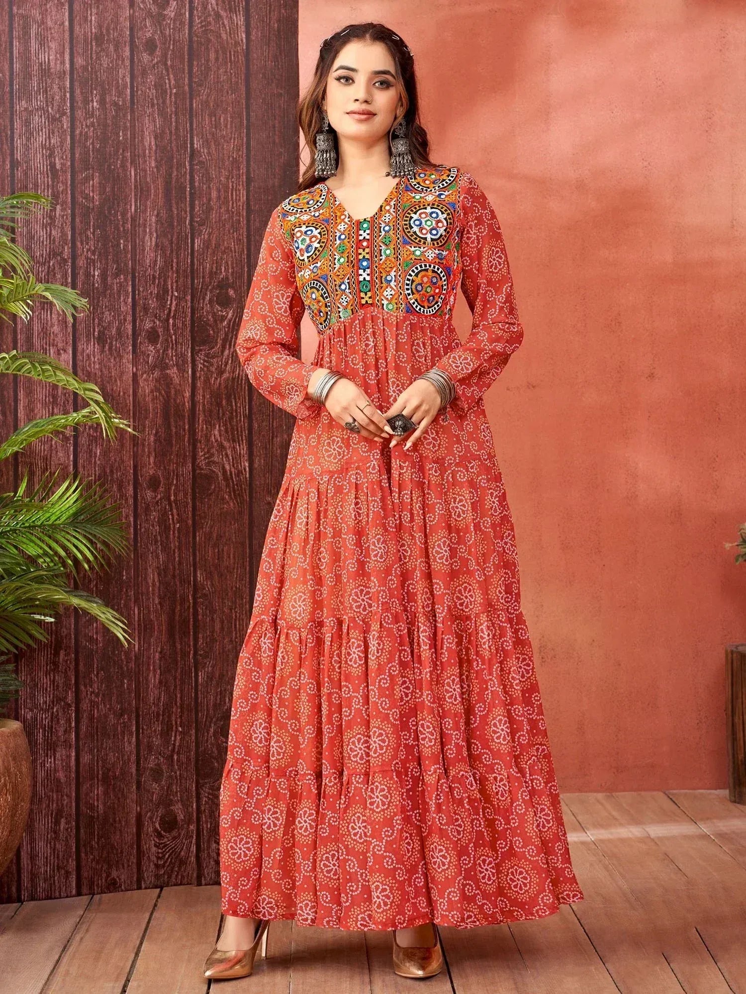 Orange ethnic gown with mirror work and floral print, perfect for Indian occasions