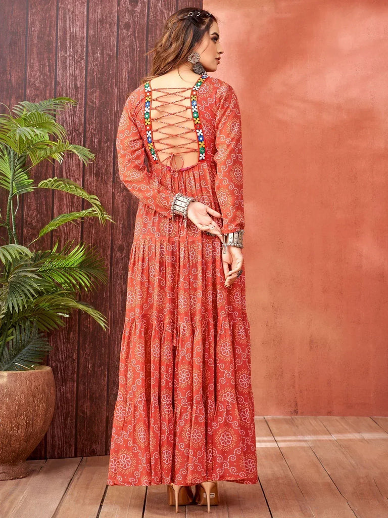 Orange floral print ethnic gown with back crisscross detailing and colorful embroidery, perfect for Indian occasions.