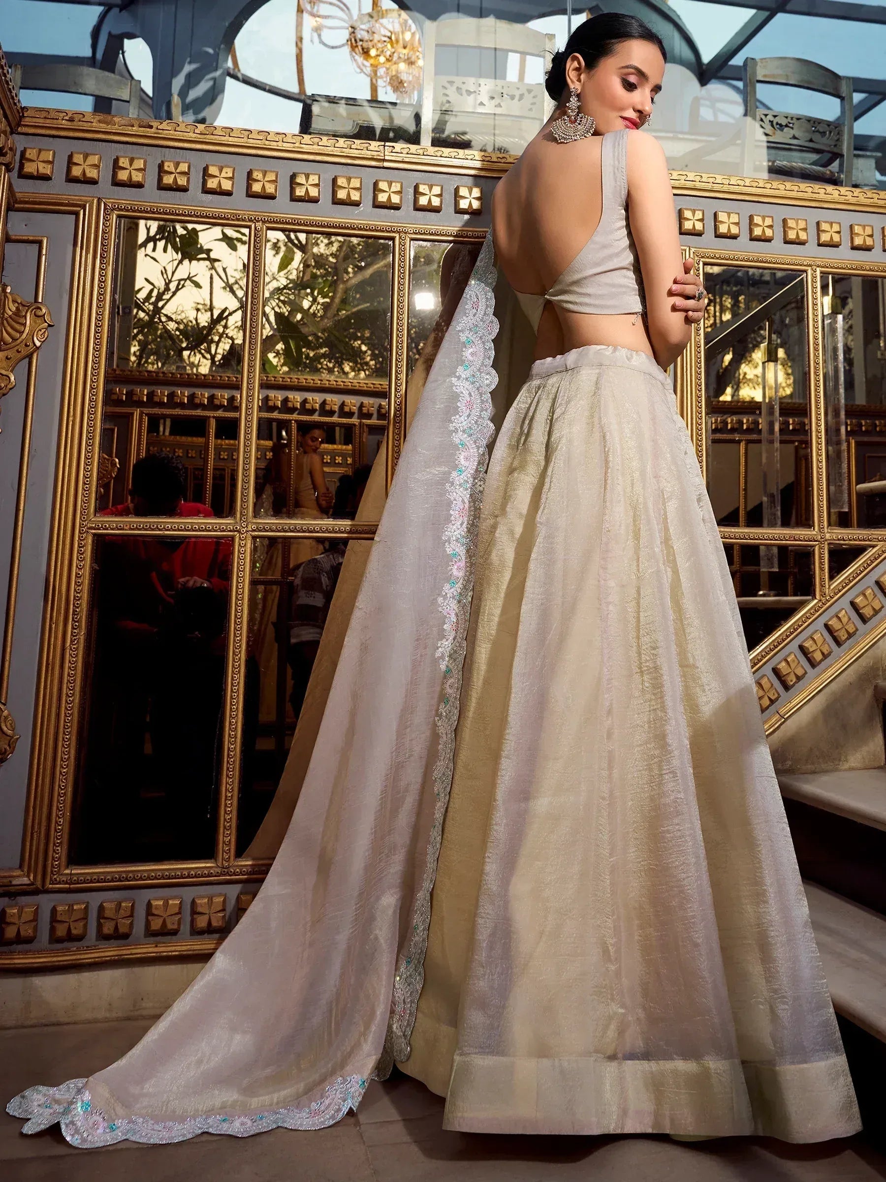 Elegant off-white lehenga choli with backless blouse and embroidered dupatta, perfect for Indian weddings and festive occasions.