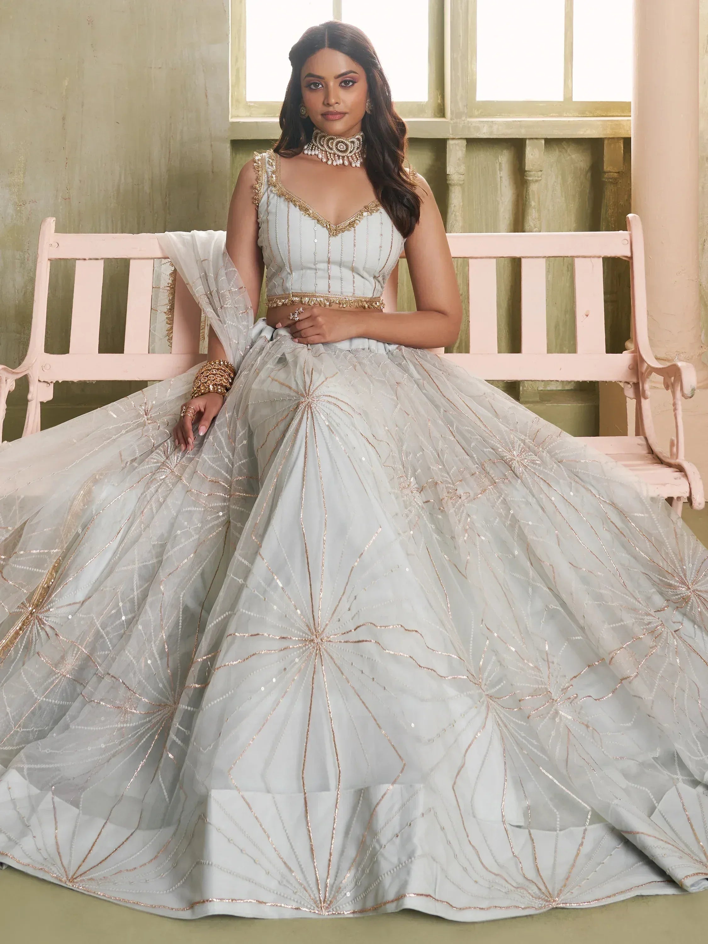 Elegant light blue lehenga choli with gold embroidery, perfect for Indian weddings and festive occasions.