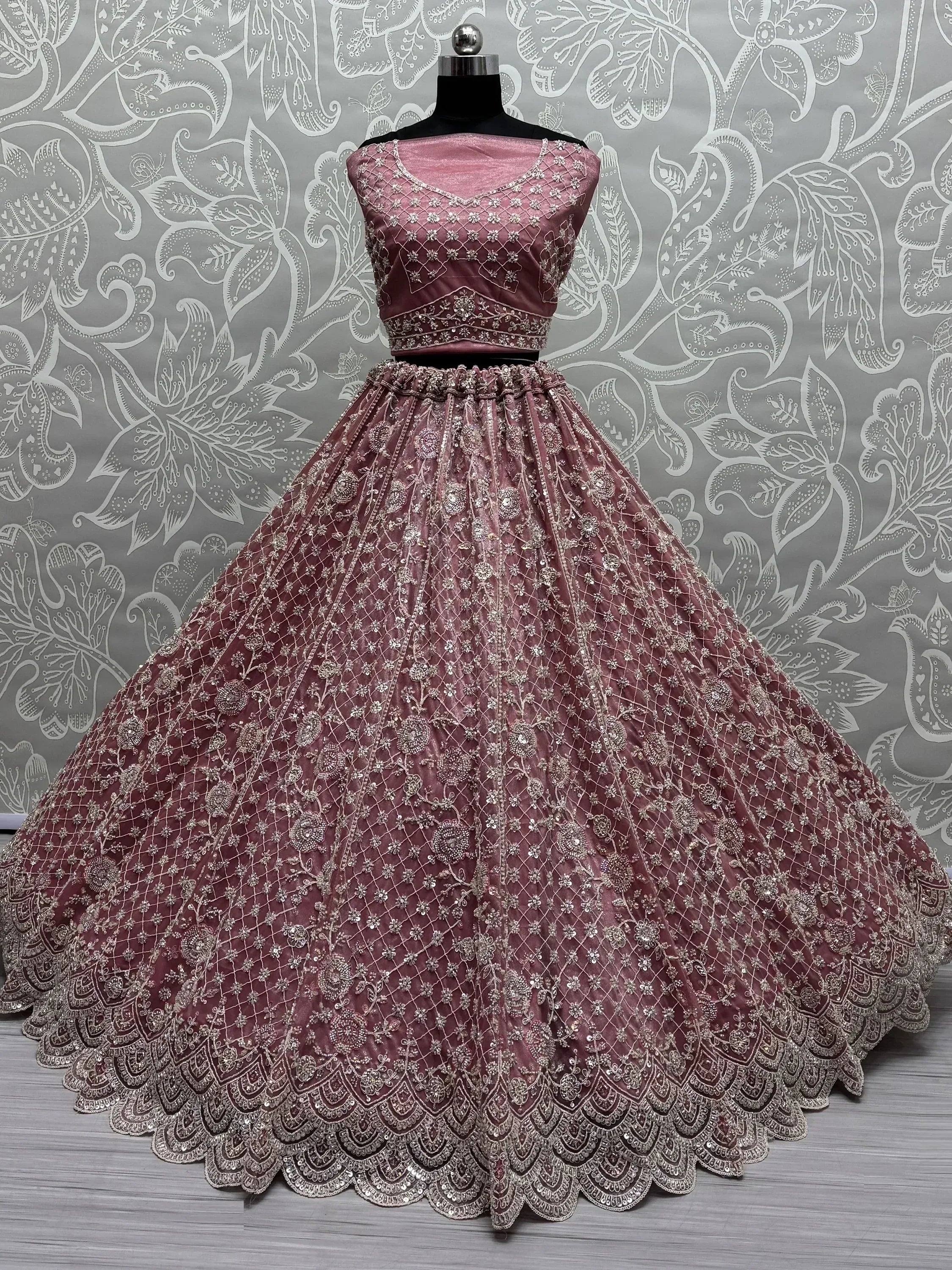 Dusty pink designer lehenga choli with intricate silver embroidery and scalloped hem, perfect for weddings