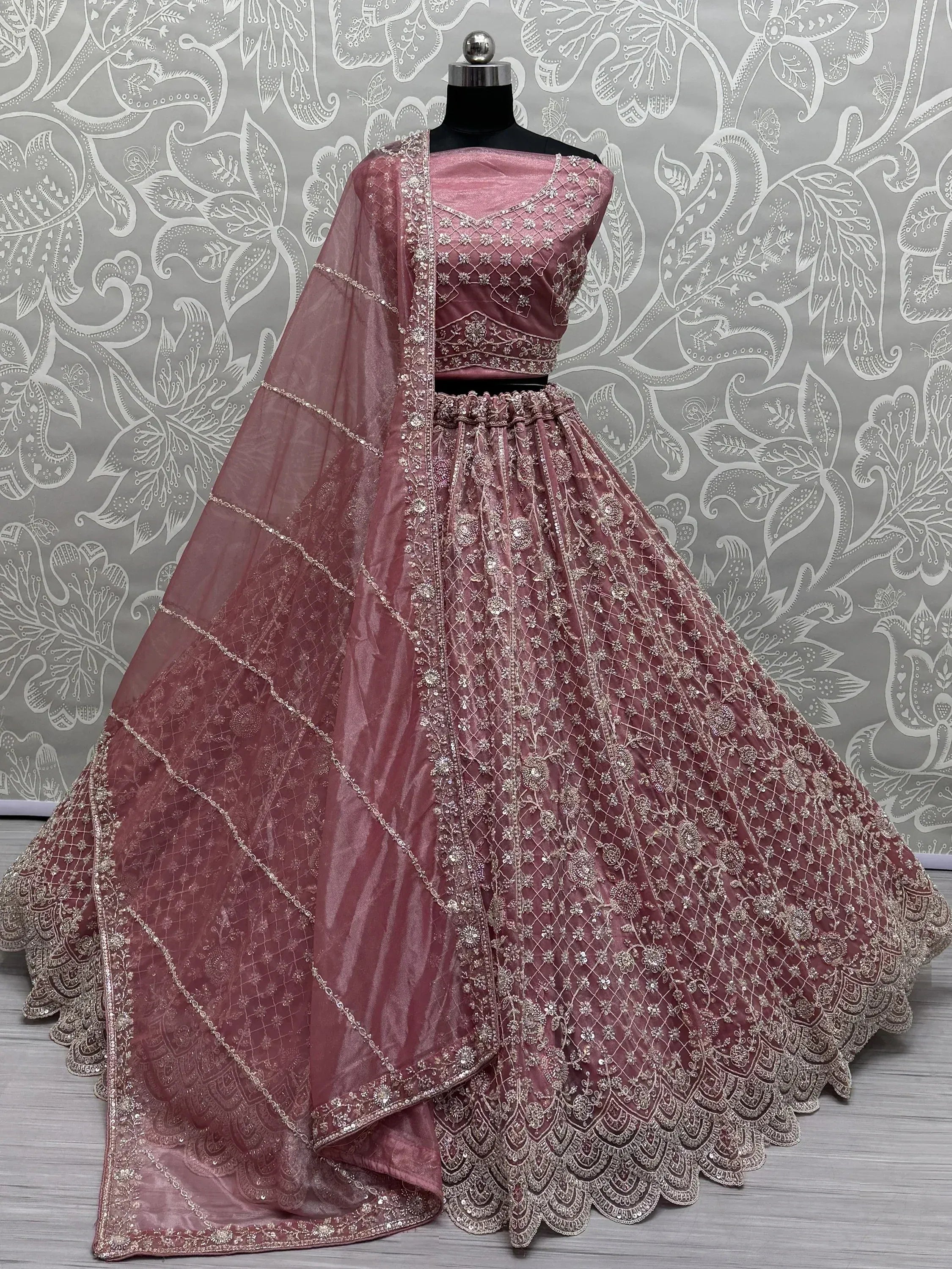 Dusty pink embroidered lehenga choli with net dupatta, perfect for Indian weddings and festive occasions.