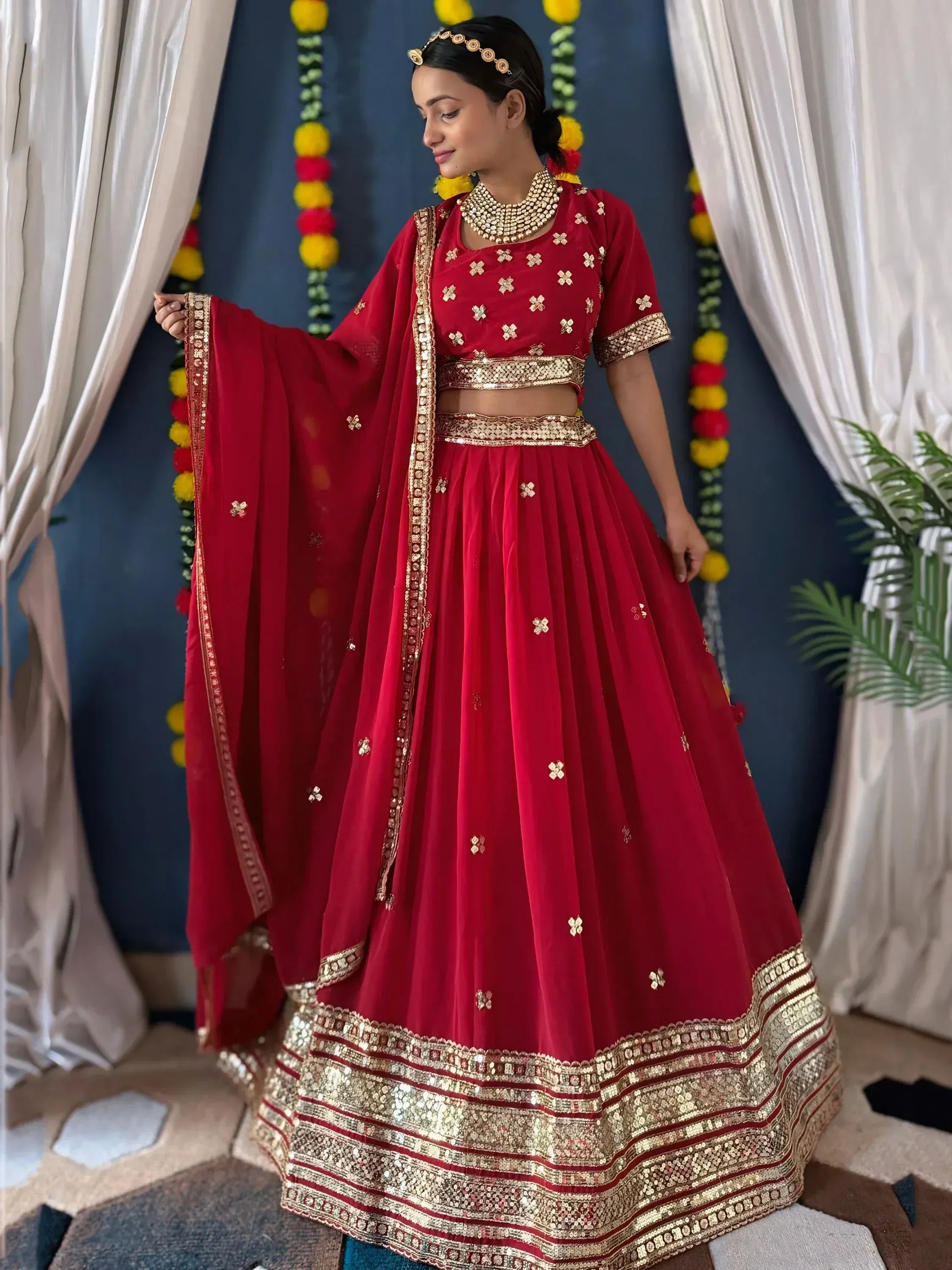Red designer lehenga choli with gold embroidery and mirror work, perfect for Indian weddings and festivals