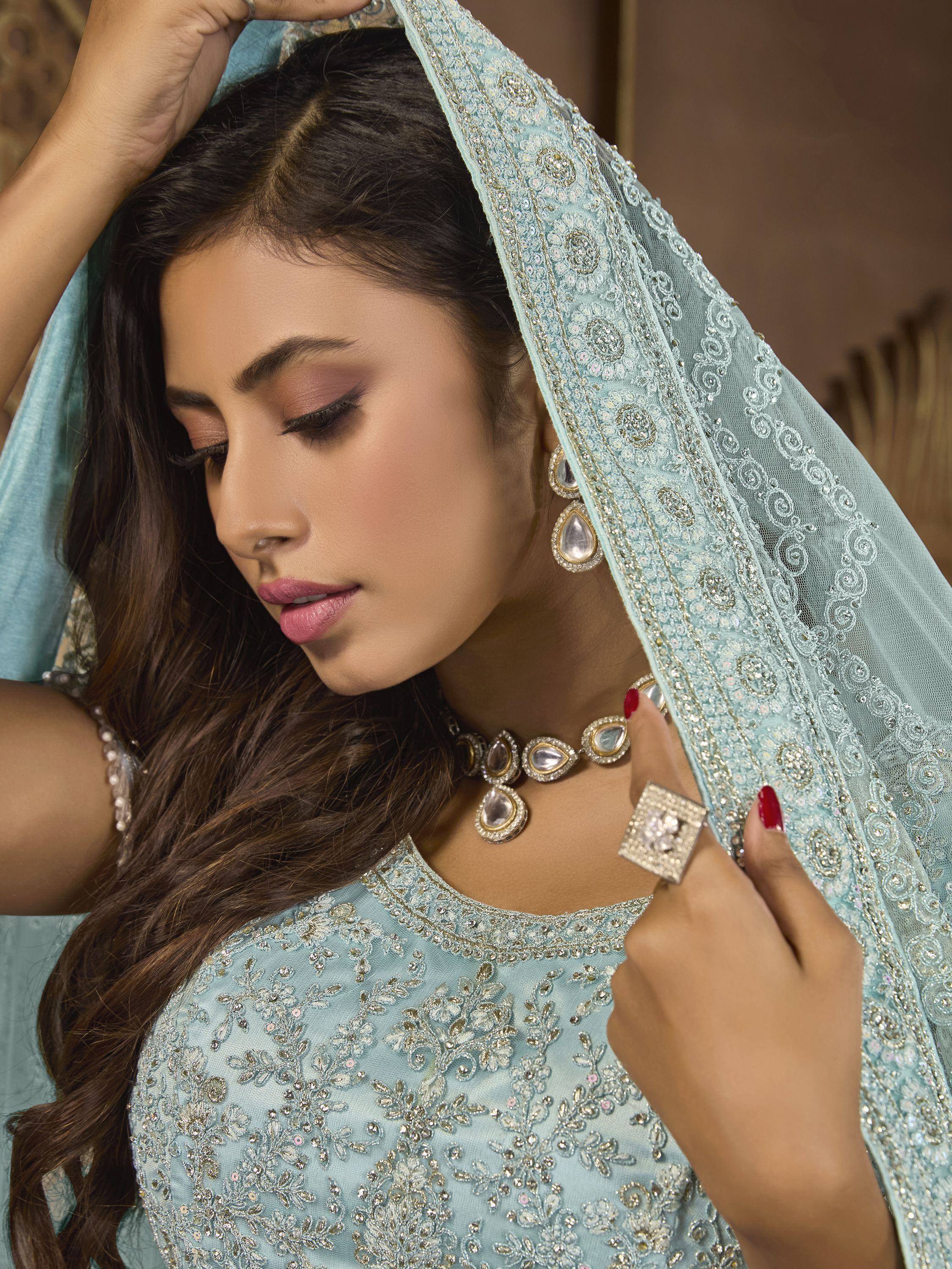Elegant woman in light blue embroidered ethnic gown with matching dupatta and traditional jewelry