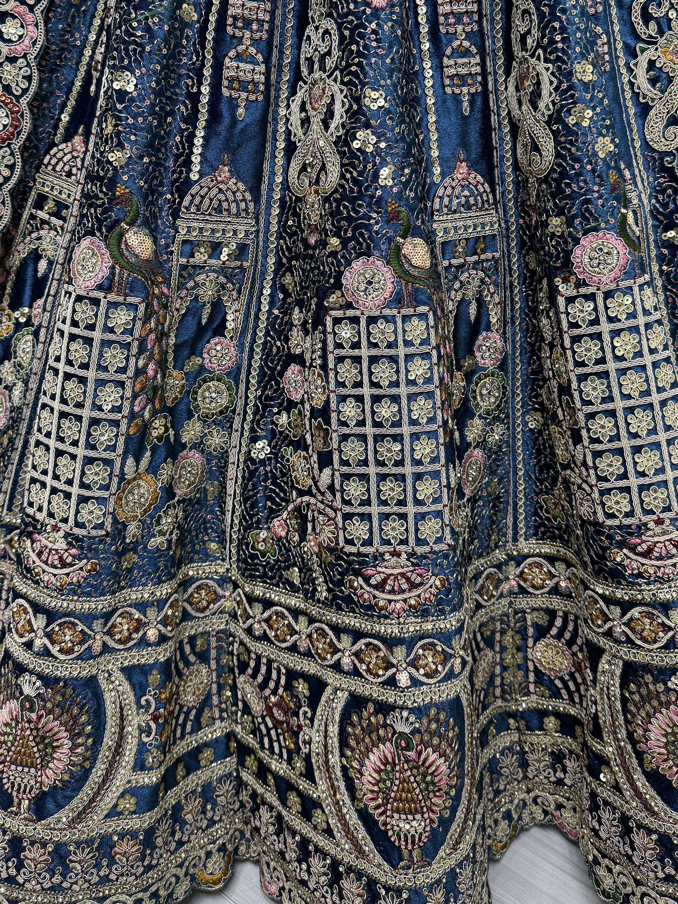 Blue embroidered lehenga with peacock and floral motifs, sequins, and intricate gold threadwork.