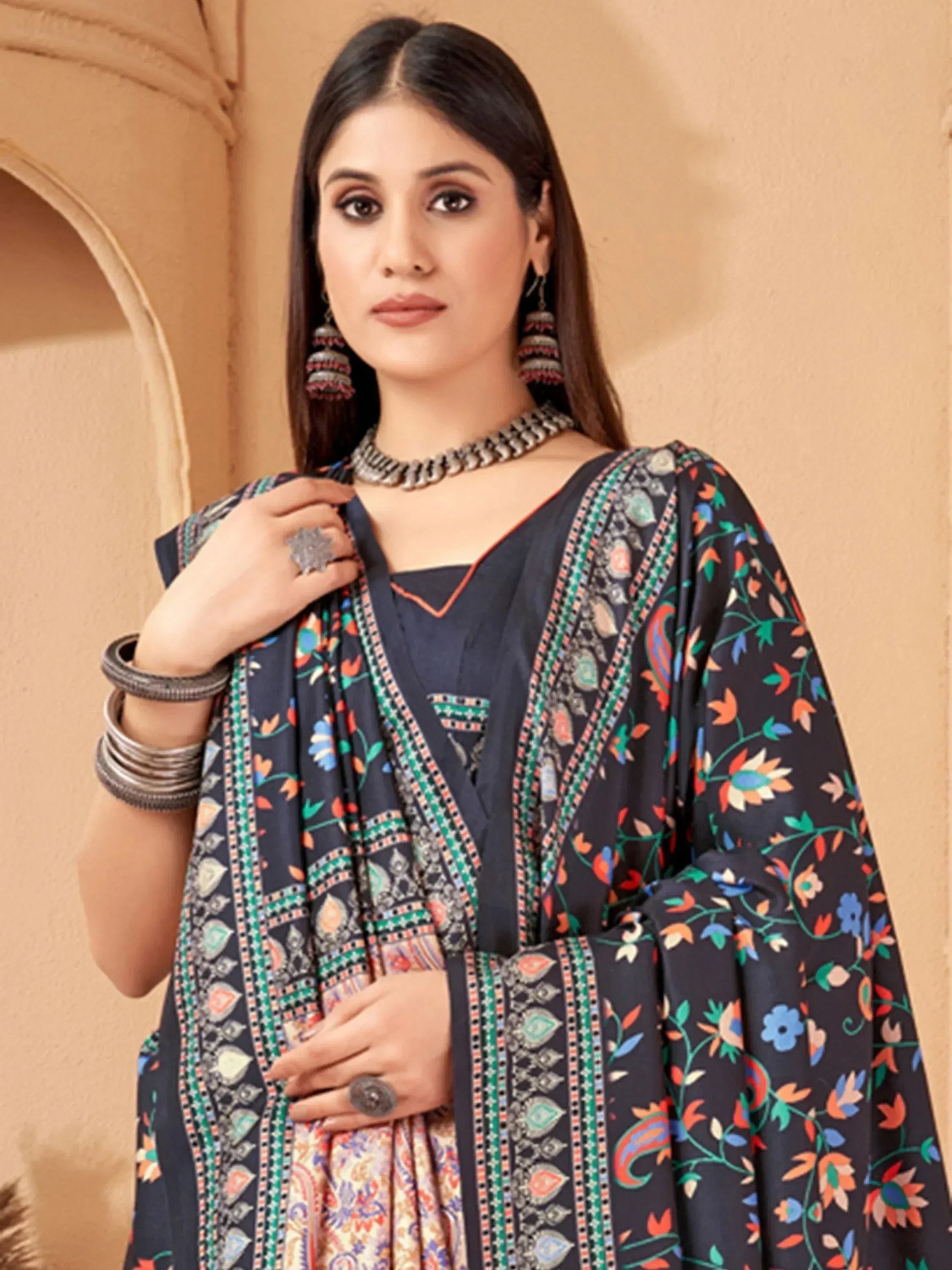 Woman in navy floral print Indian ethnic salwar kameez with traditional jewelry and dupatta