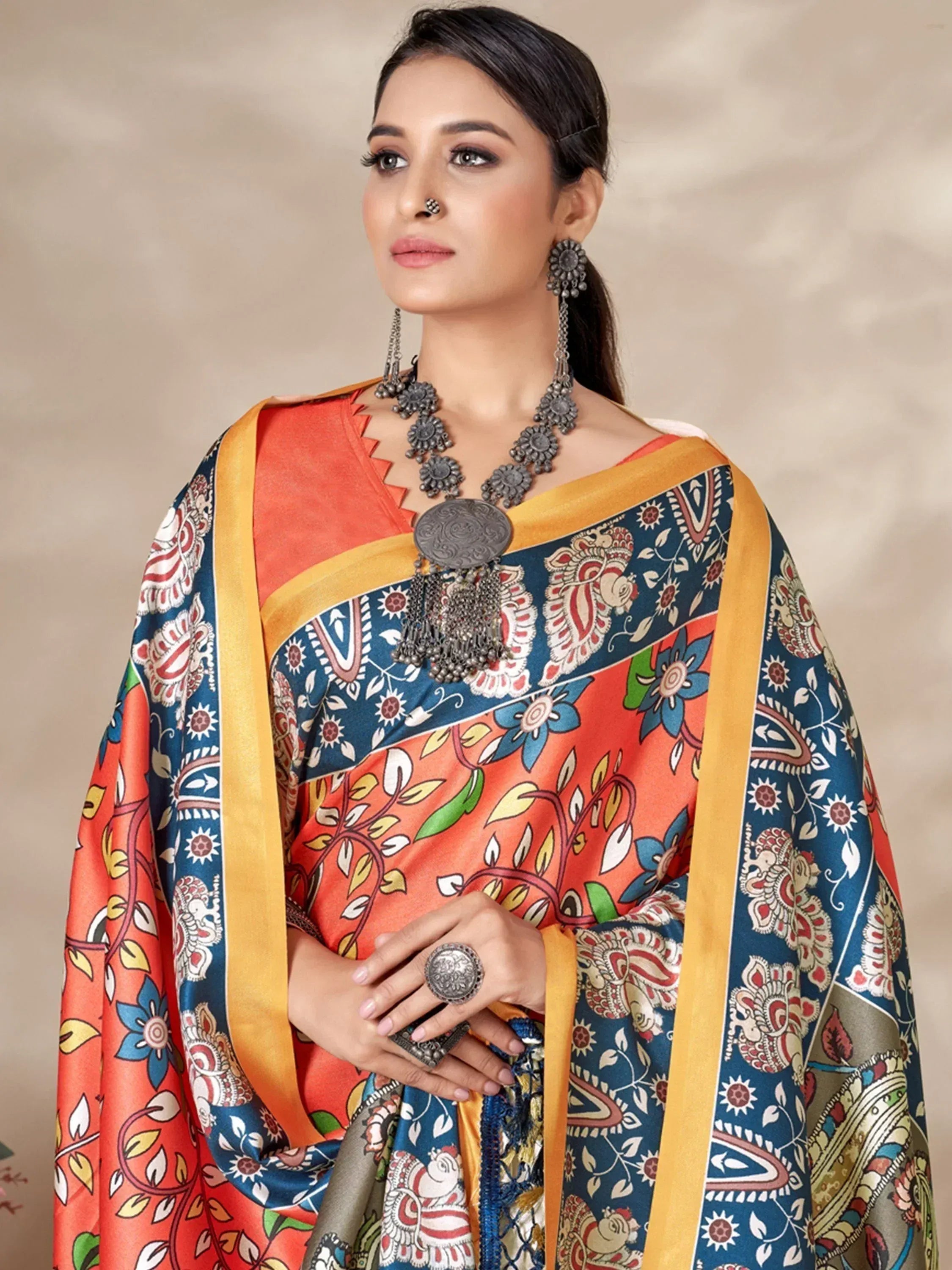 Woman in vibrant Indian ethnic saree with floral and paisley print, paired with traditional jewelry