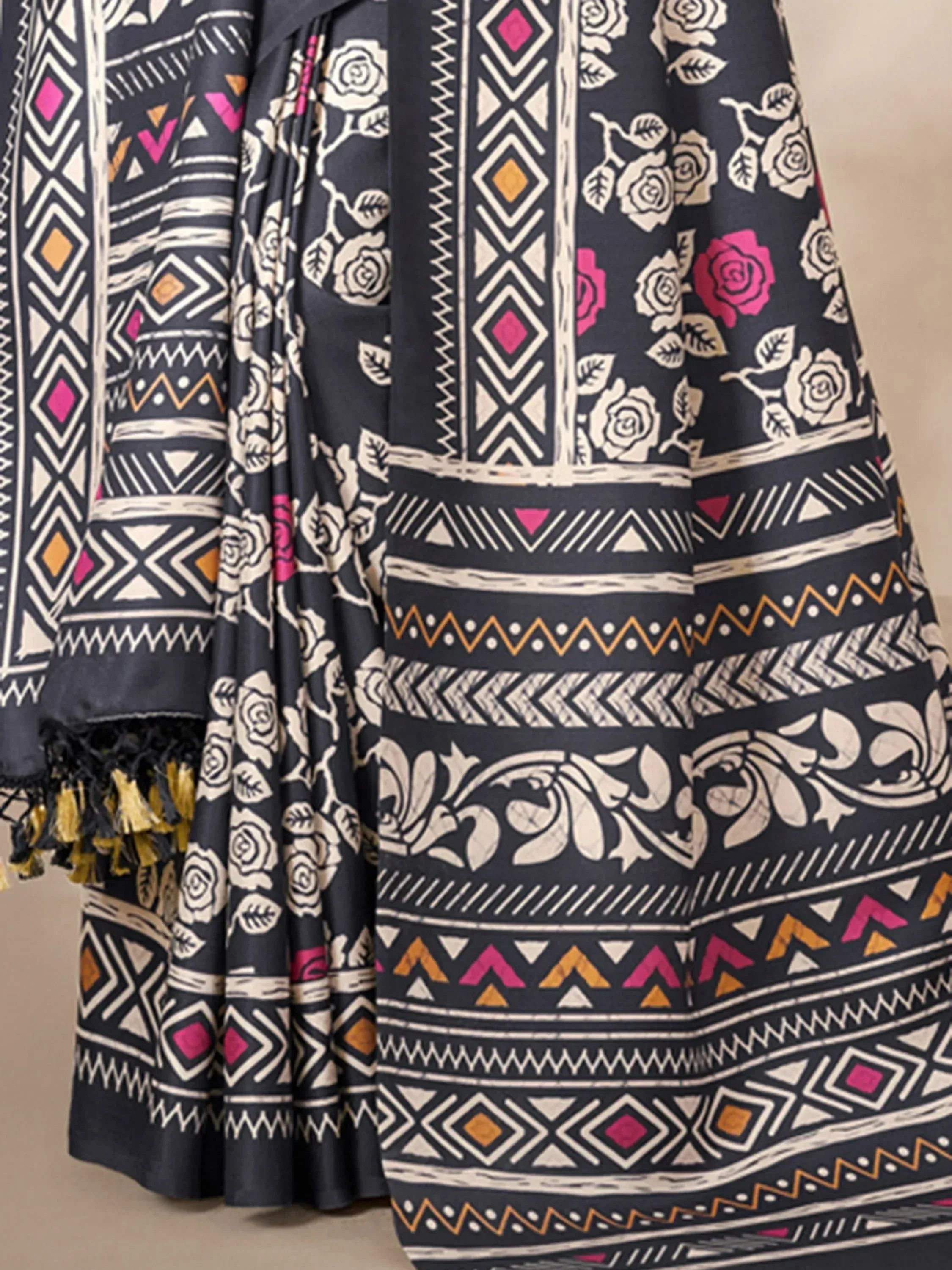 Black ethnic gown with floral and geometric print, pink and gold accents, tassel details