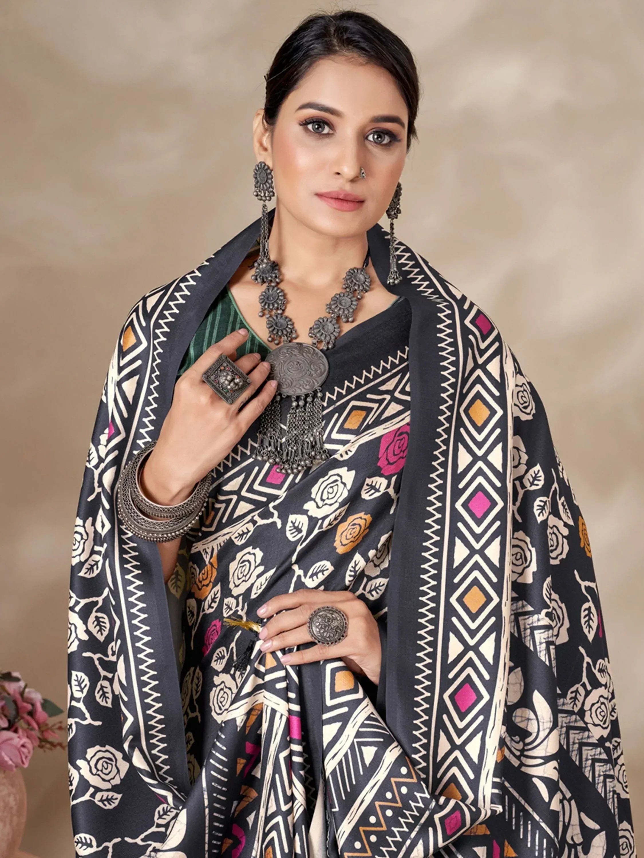 Woman in black floral and geometric print saree with silver tribal jewelry, ethnic Indian wear