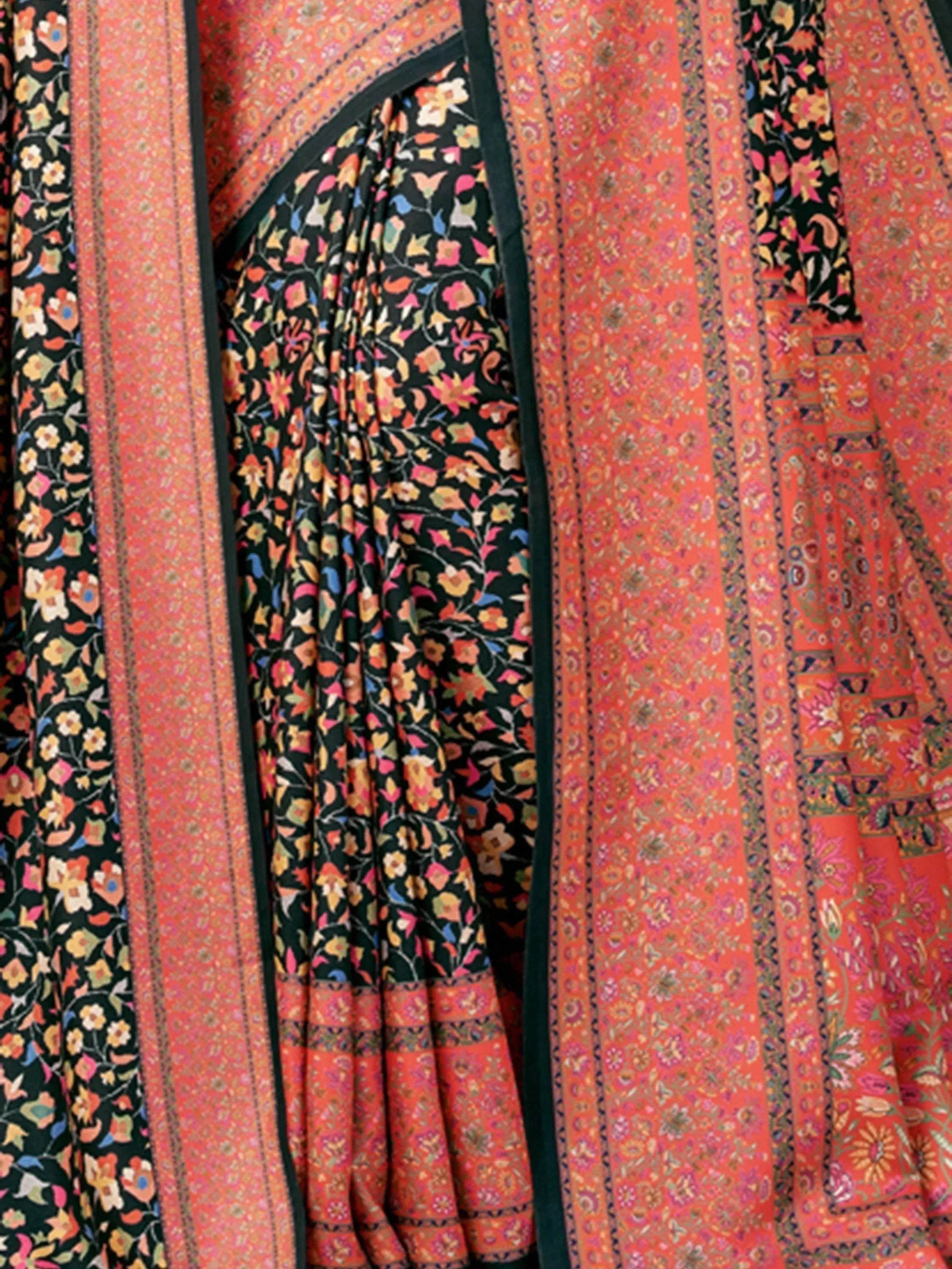 Vibrant floral print saree with intricate orange and black patterns, perfect for ethnic wear.