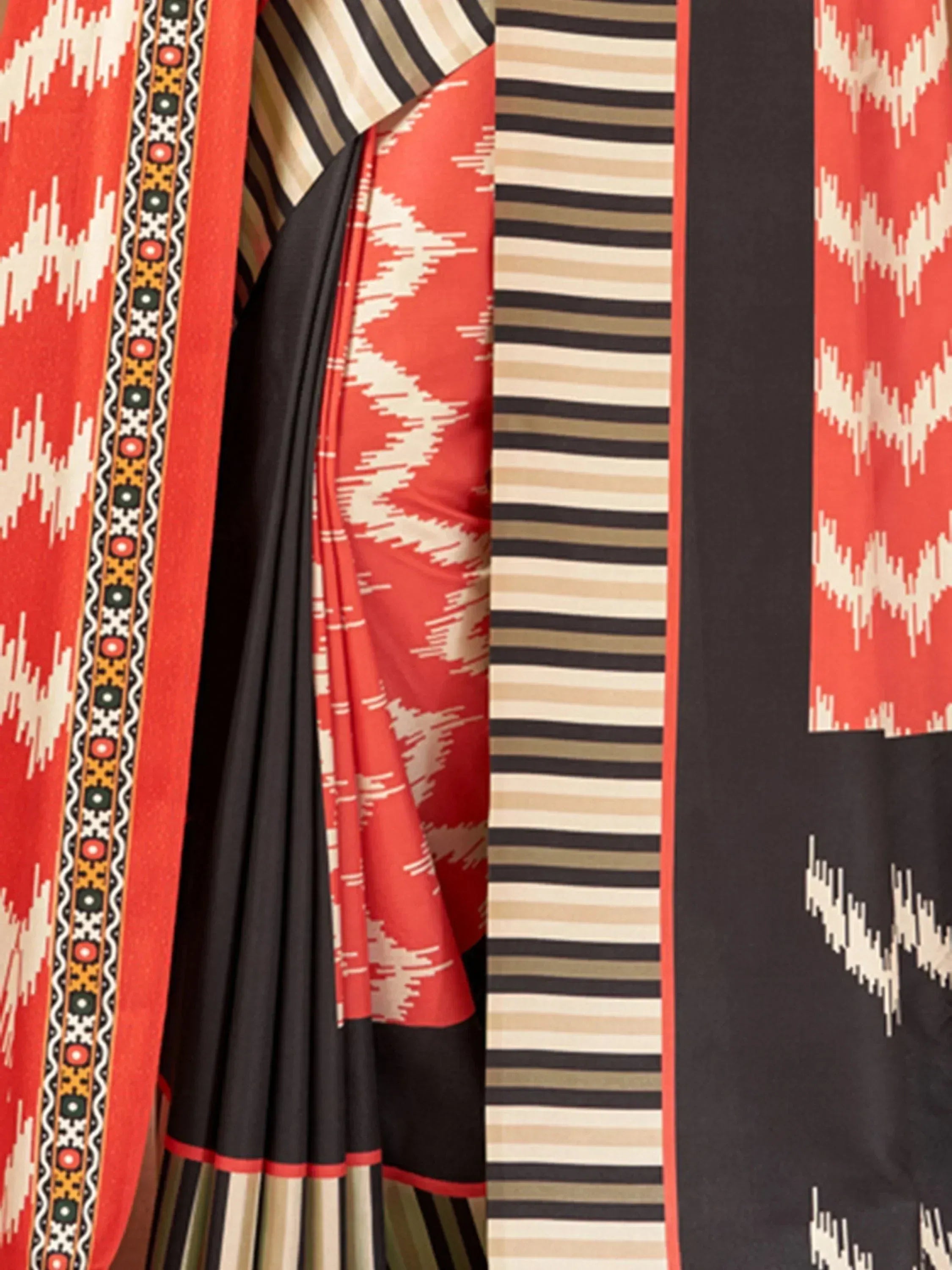 Red and black ethnic saree with geometric ikat print and striped border, perfect for Indian occasions