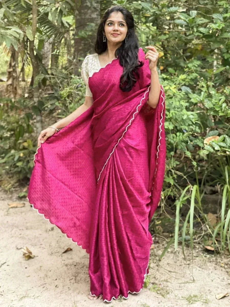 Woman in vibrant pink ethnic saree with scalloped border, styled with lace blouse, perfect for Indian occasions