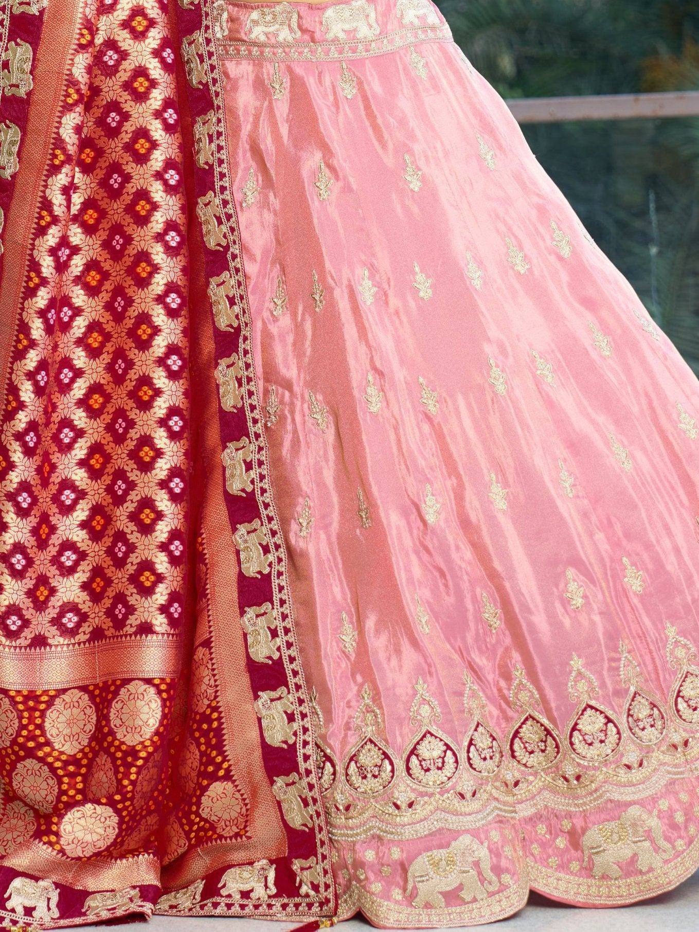 Pink and maroon designer lehenga with gold elephant embroidery and floral motifs, perfect for Indian ethnic wear.