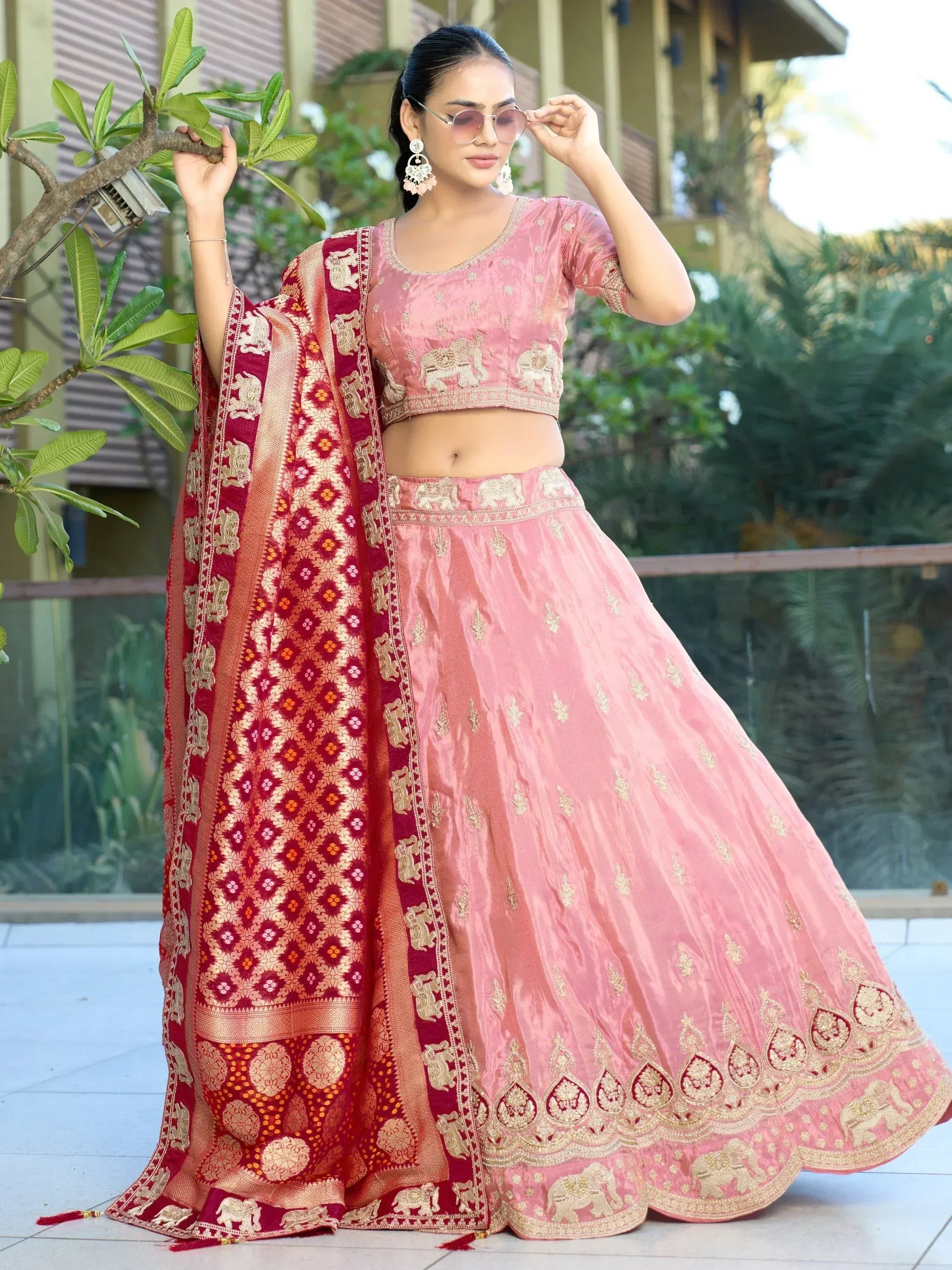 Pink embroidered lehenga choli with red dupatta, featuring elephant motifs and gold detailing for Indian ethnic wear.