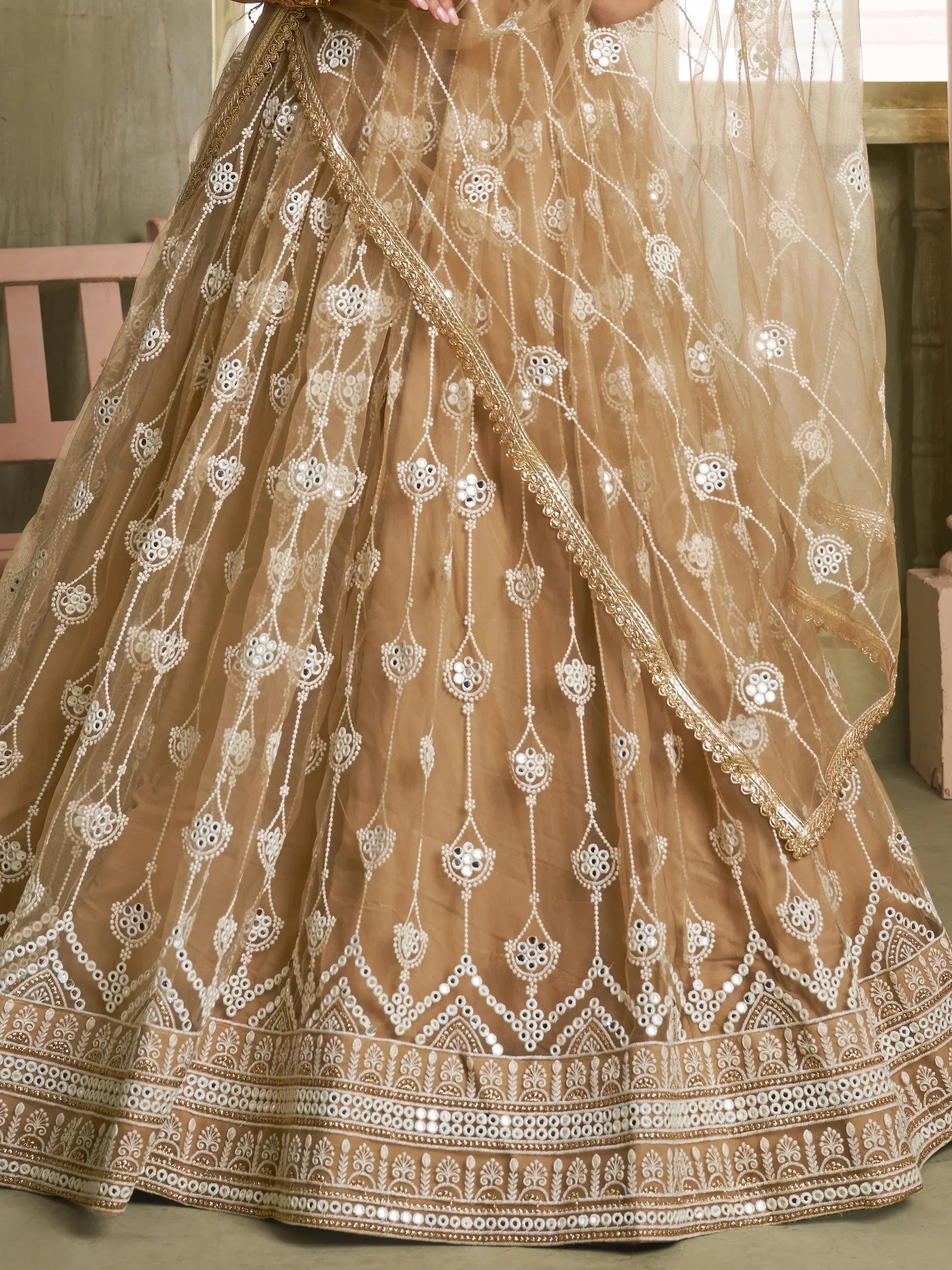 Elegant beige lehenga choli with intricate mirror and thread embroidery, perfect for Indian weddings and festive occasions.