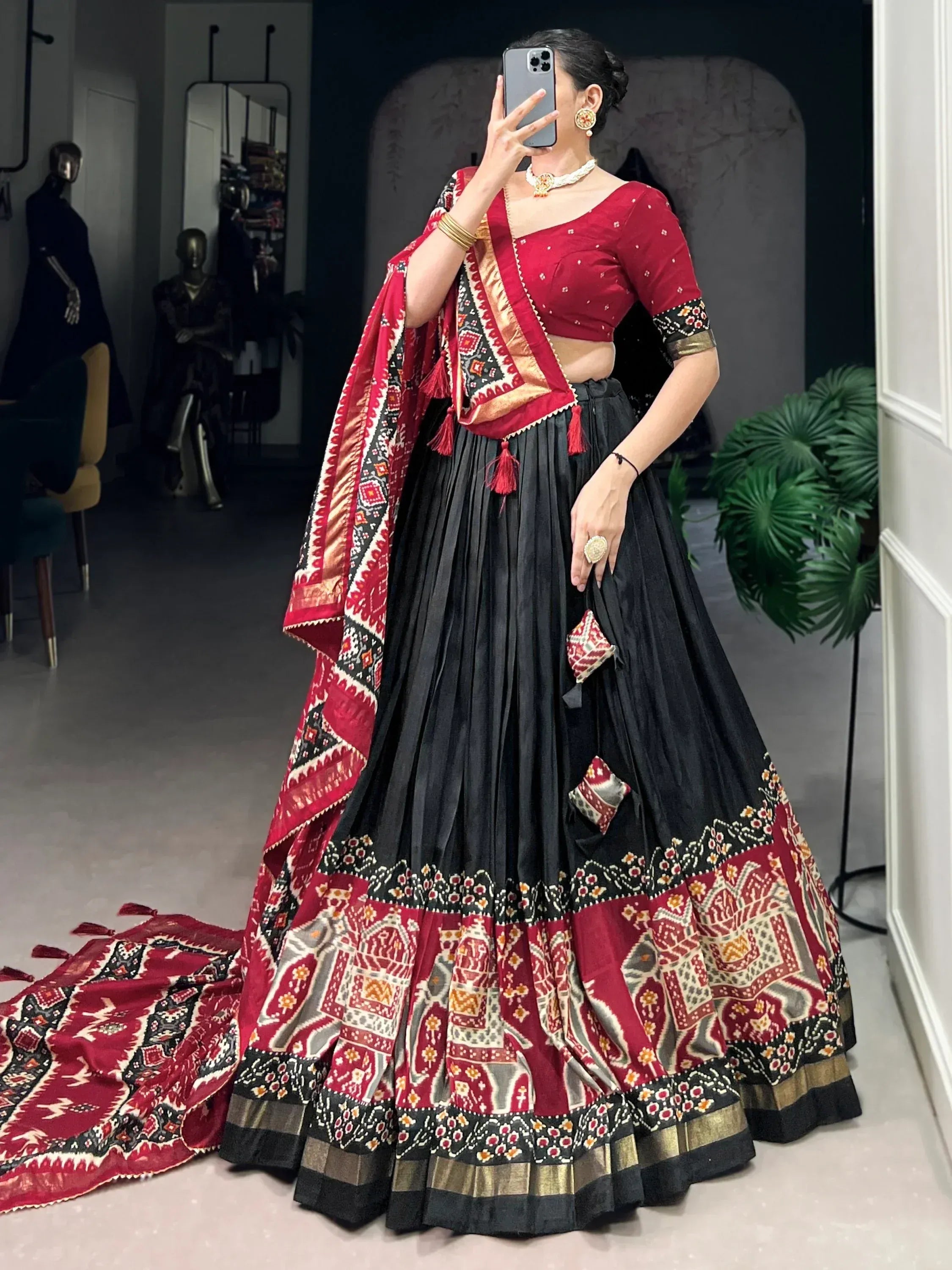 Red and black ethnic lehenga choli with printed dupatta, perfect for Indian weddings and festive occasions.