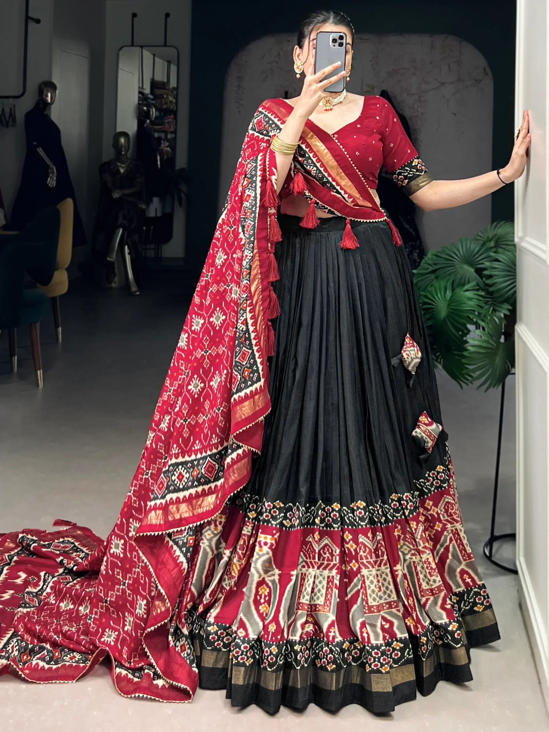 Red and black printed lehenga choli with ethnic patterns, perfect for Indian weddings or festive occasions.