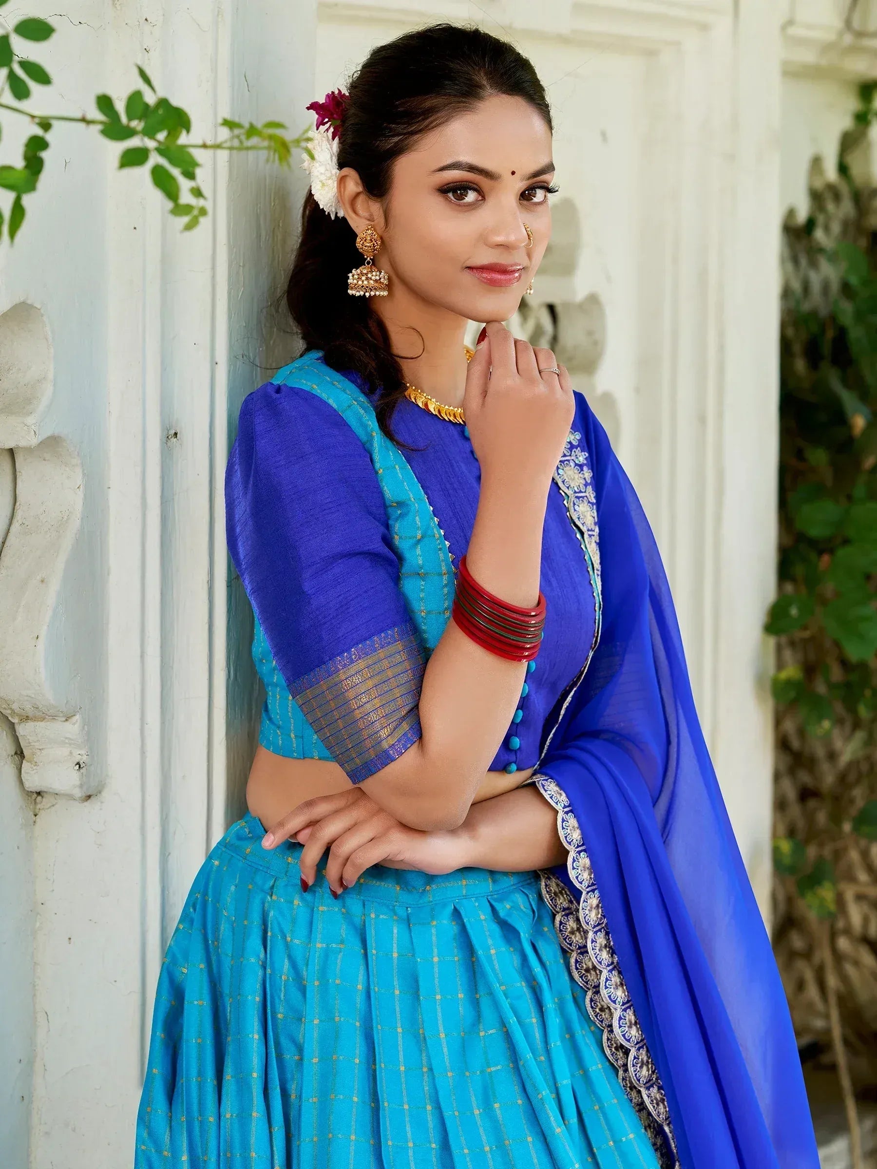 Blue and turquoise ethnic lehenga choli with gold embroidery and traditional jewelry