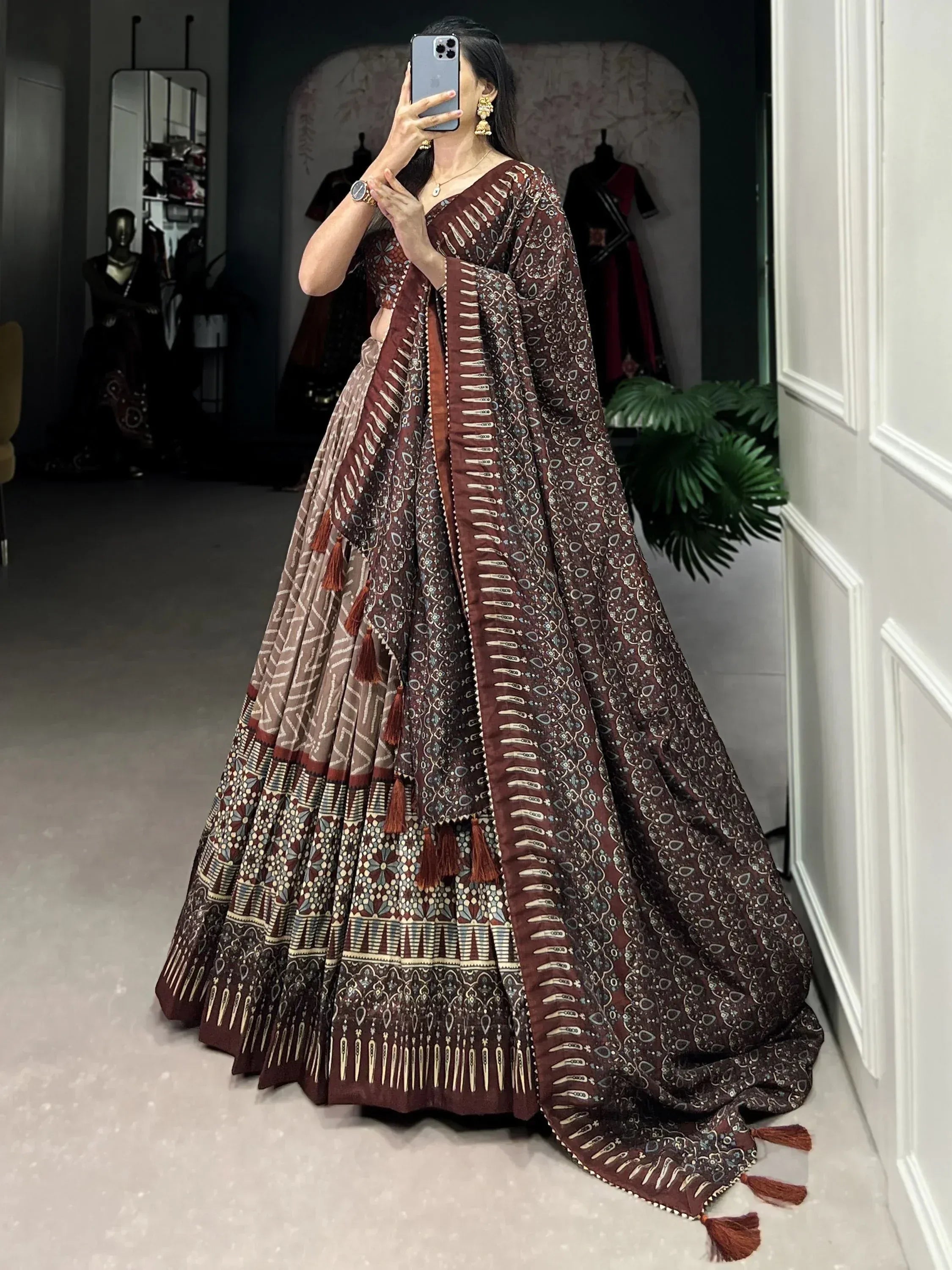 Woman in maroon printed lehenga choli with tassels, ethnic Indian wear for weddings or festivals