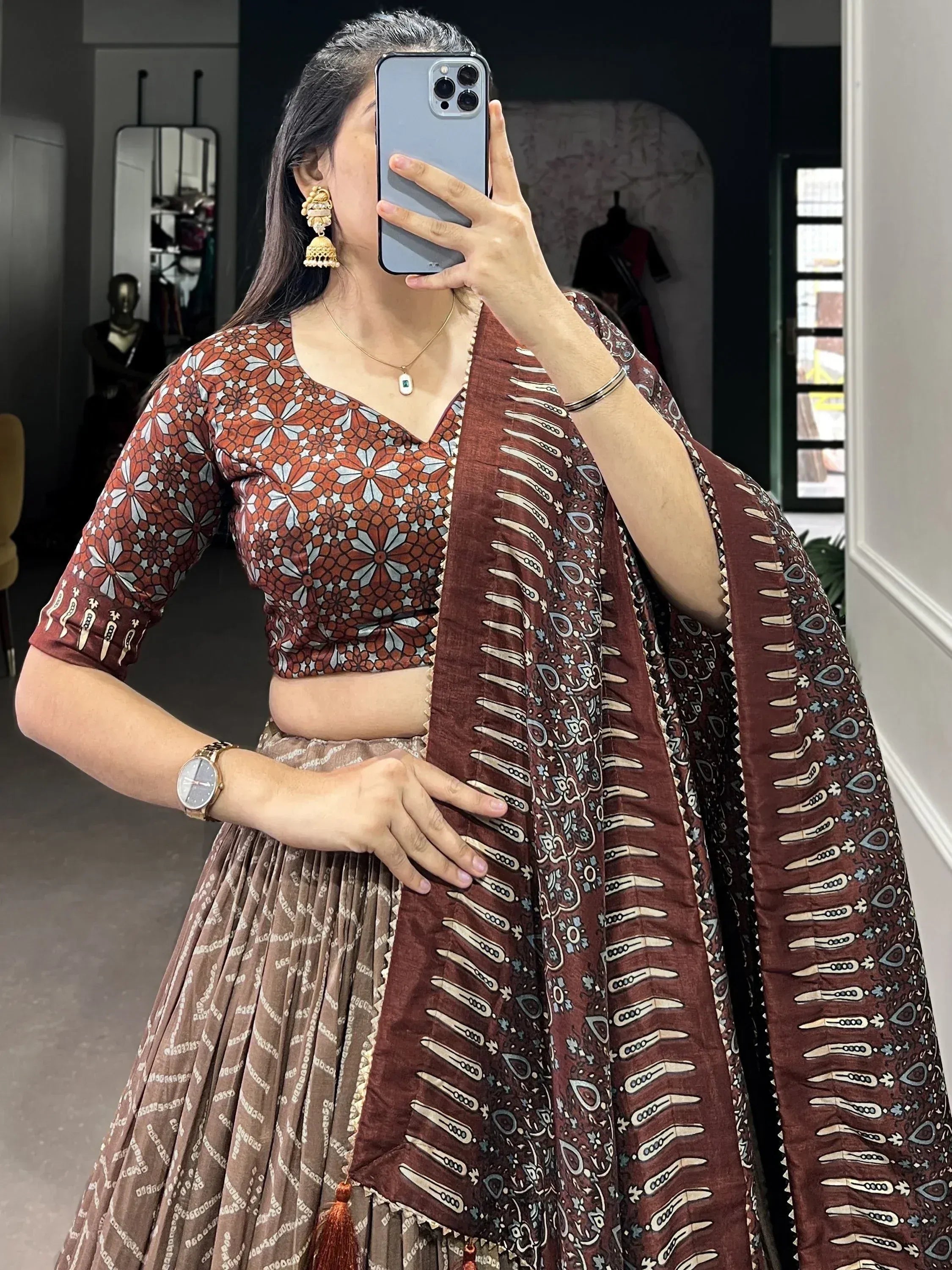 Woman wearing printed ethnic lehenga choli with matching dupatta, traditional Indian attire for festive occasions