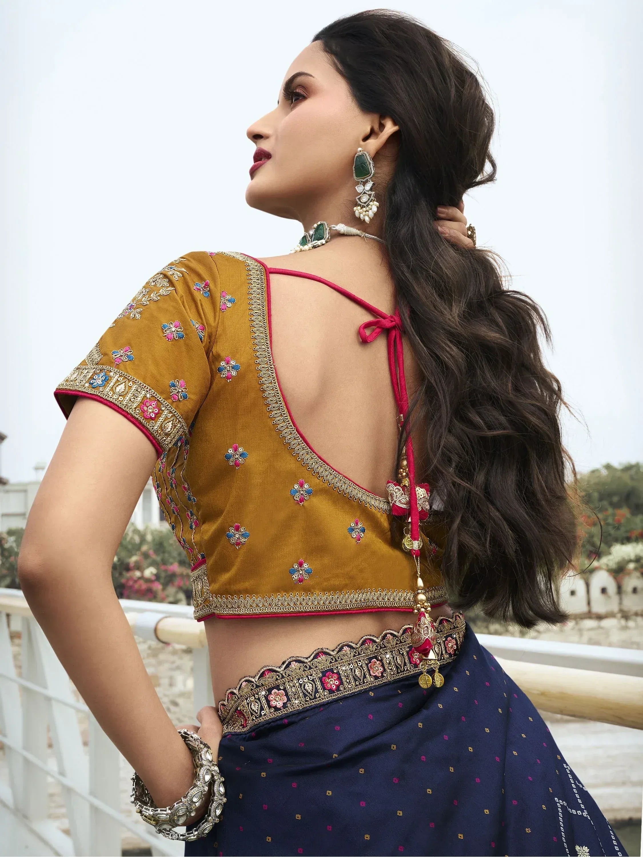 Elegant mustard blouse with floral embroidery and navy blue saree, perfect for Indian ethnic wear.