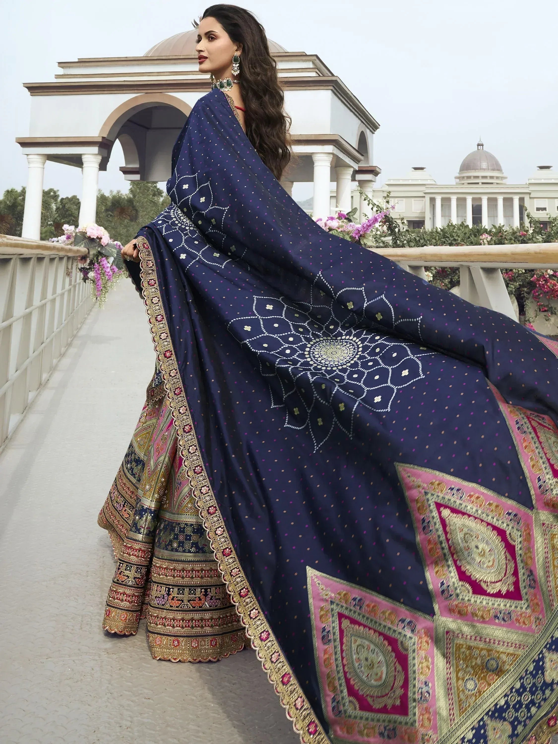 Elegant navy blue lehenga choli with intricate embroidery and vibrant pink borders, perfect for Indian ethnic wear.