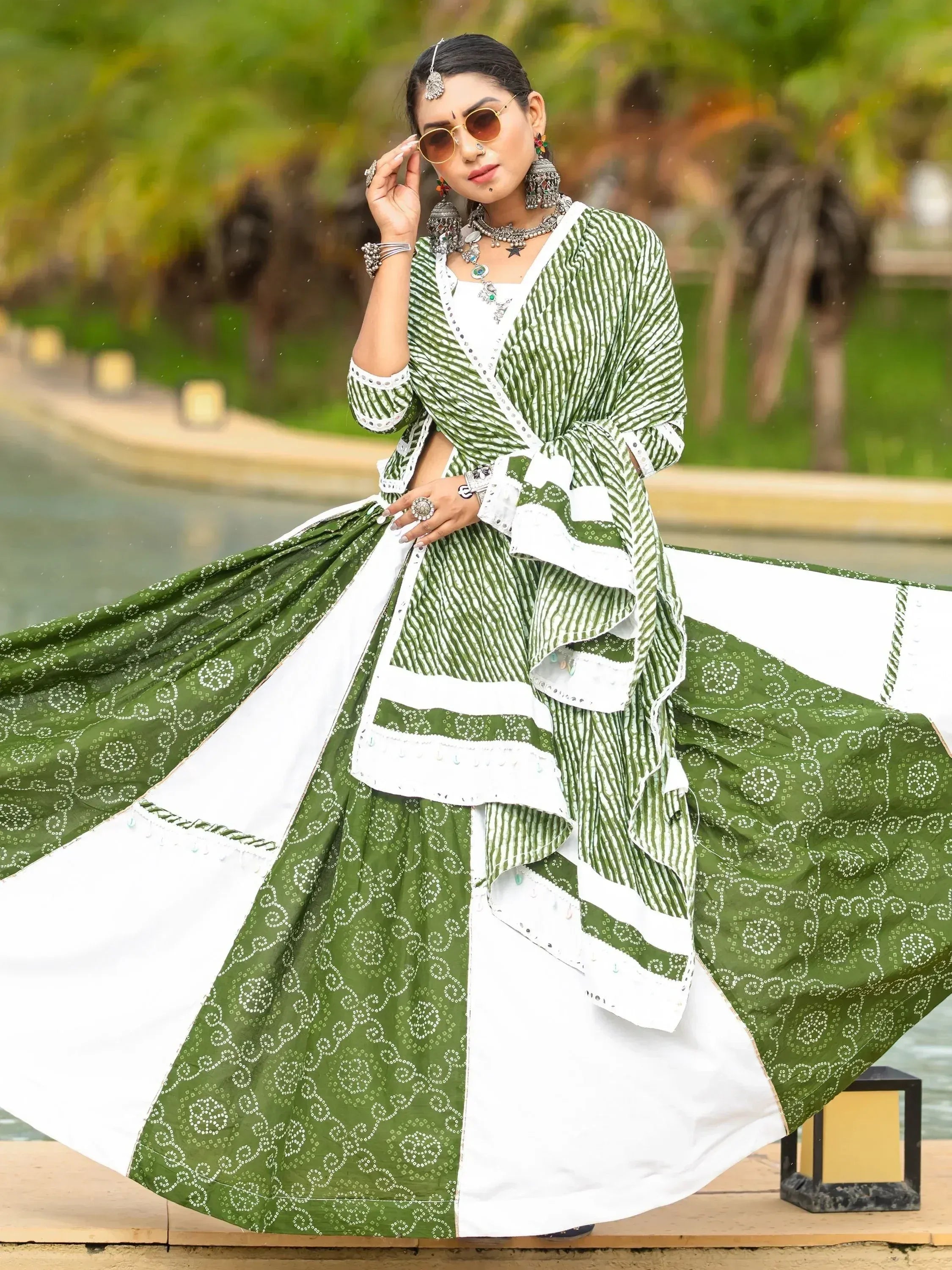 Green and white printed lehenga choli with mirror work, styled with ethnic jewelry and sunglasses