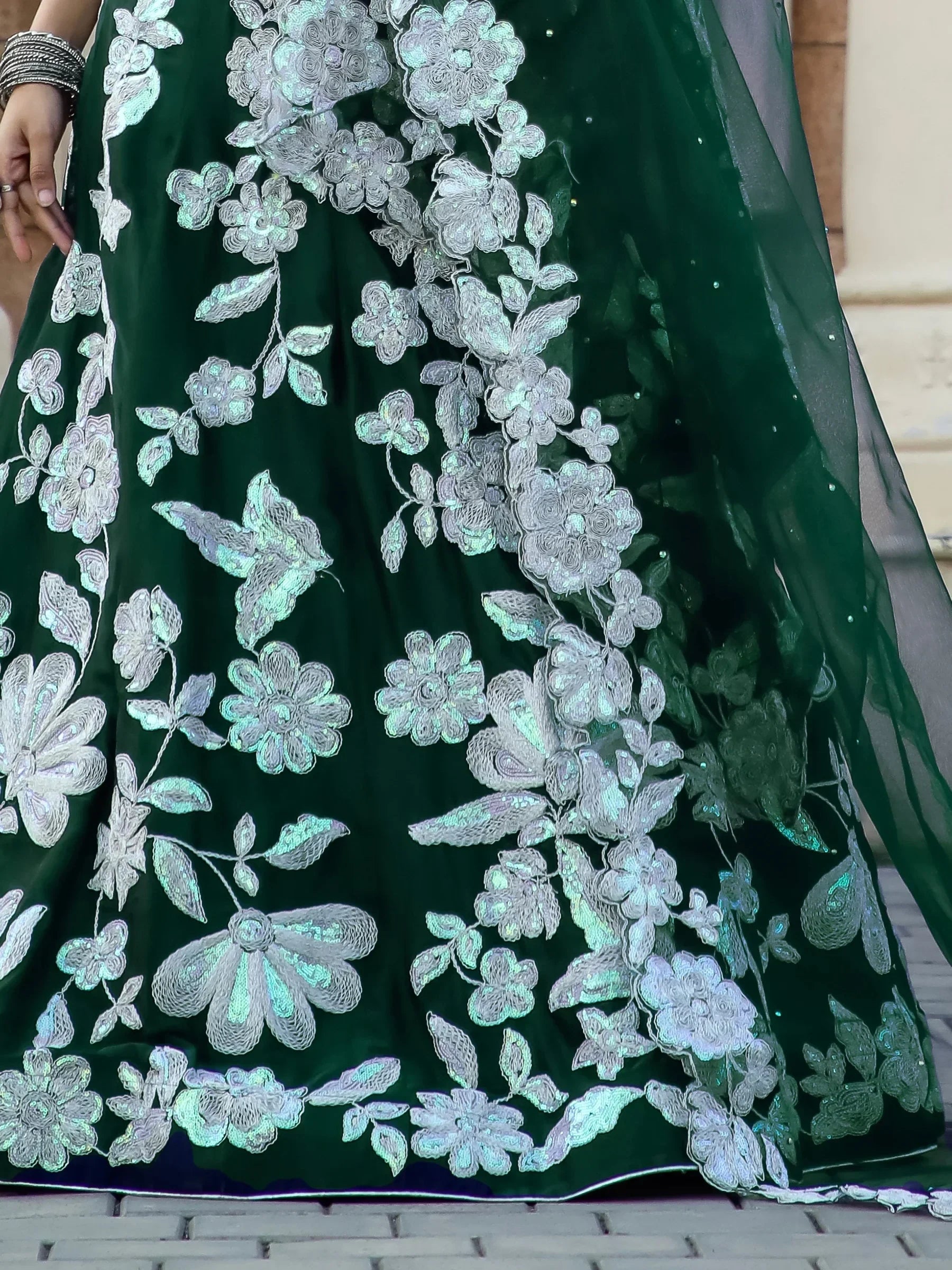 Emerald green velvet lehenga with silver floral embroidery and sequin detailing, perfect for Indian ethnic wear.