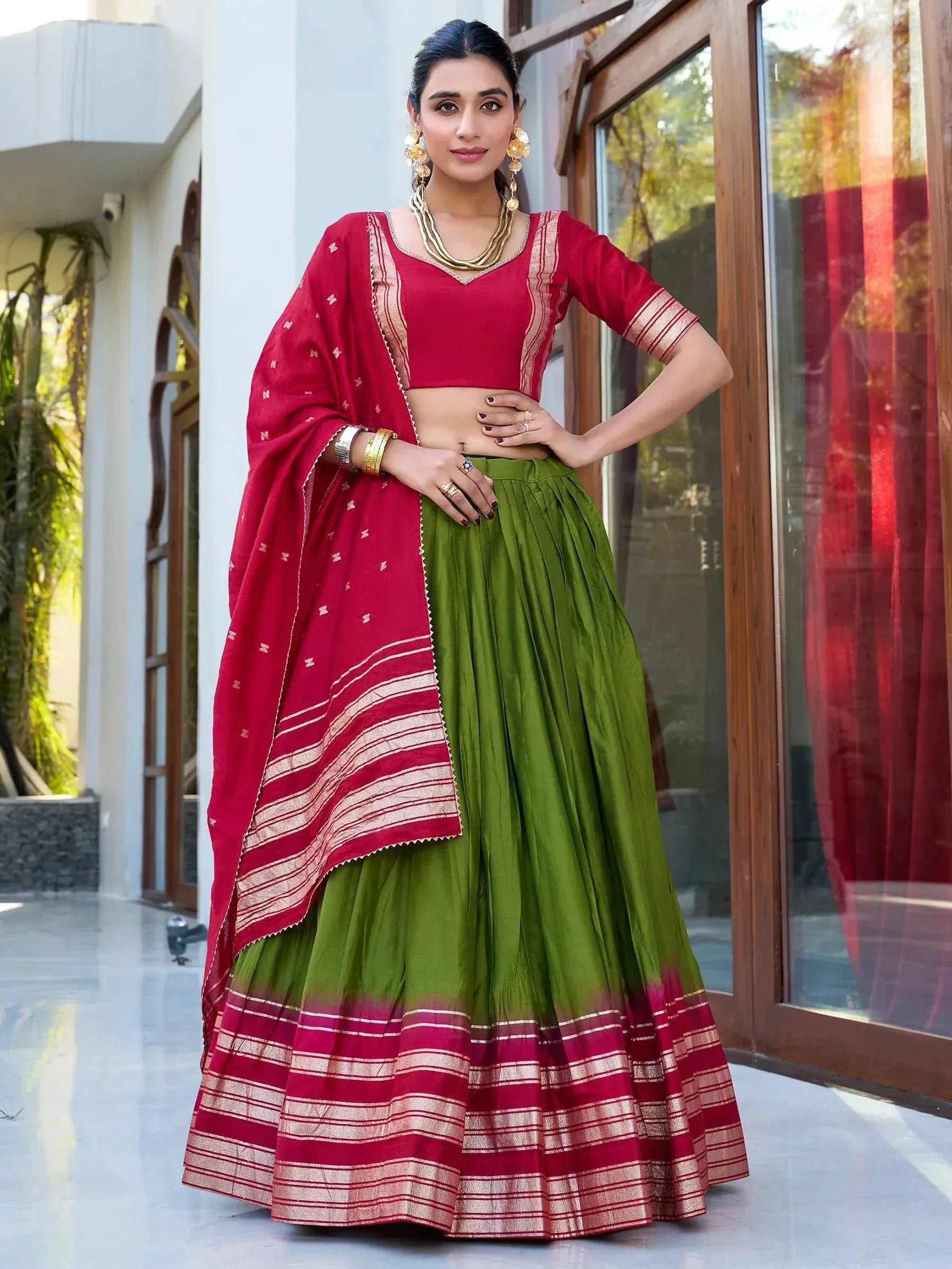 Red and green ethnic lehenga choli with gold trim, perfect for Indian weddings and festivals