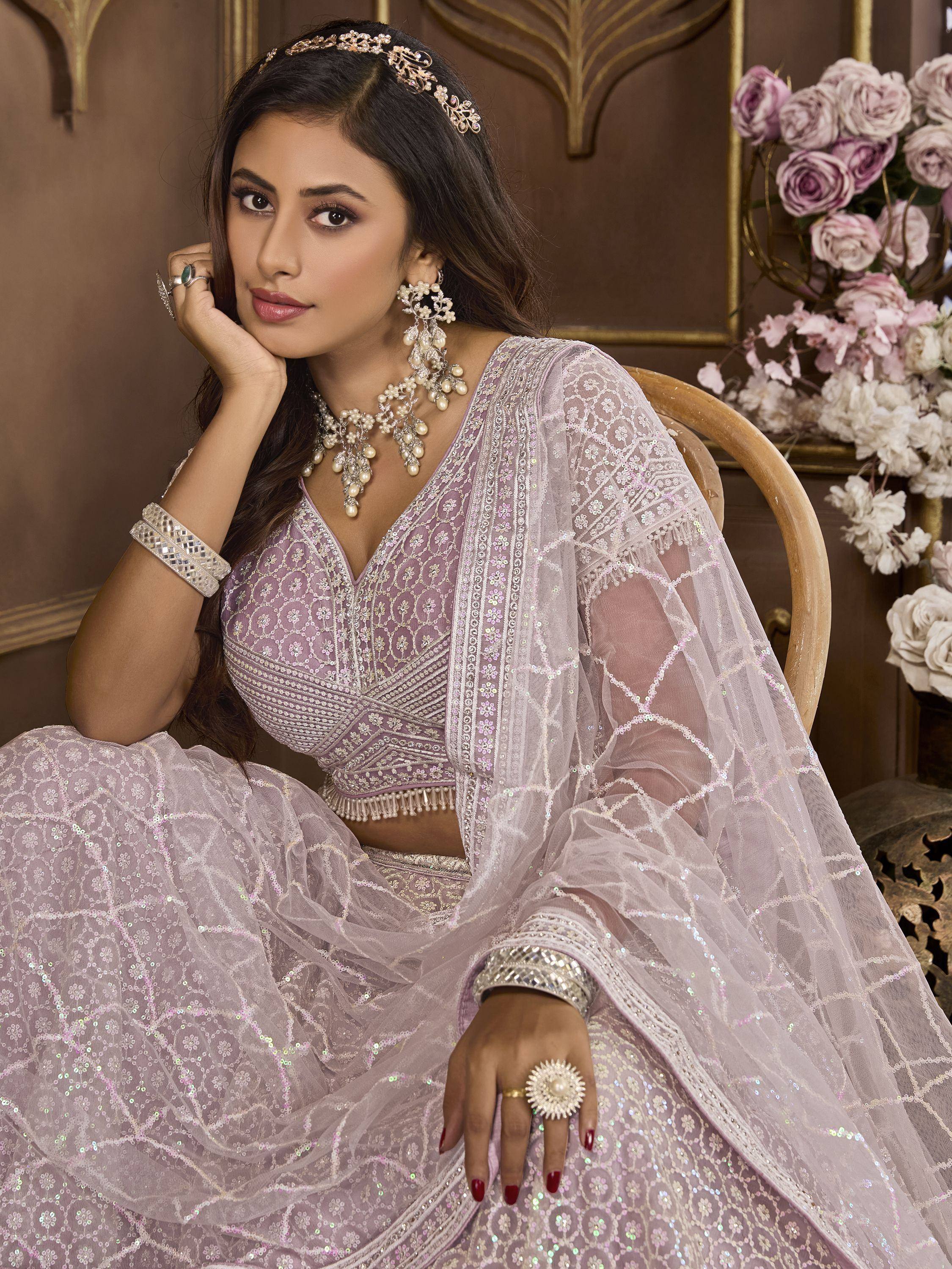 Elegant lavender lehenga choli with intricate embroidery and pearl jewelry for Indian ethnic wear