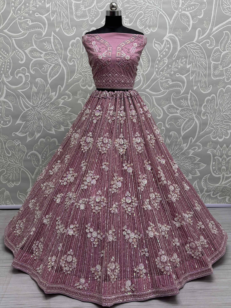Dusty pink designer lehenga choli with floral embroidery and sequin work, perfect for weddings and festive occasions.