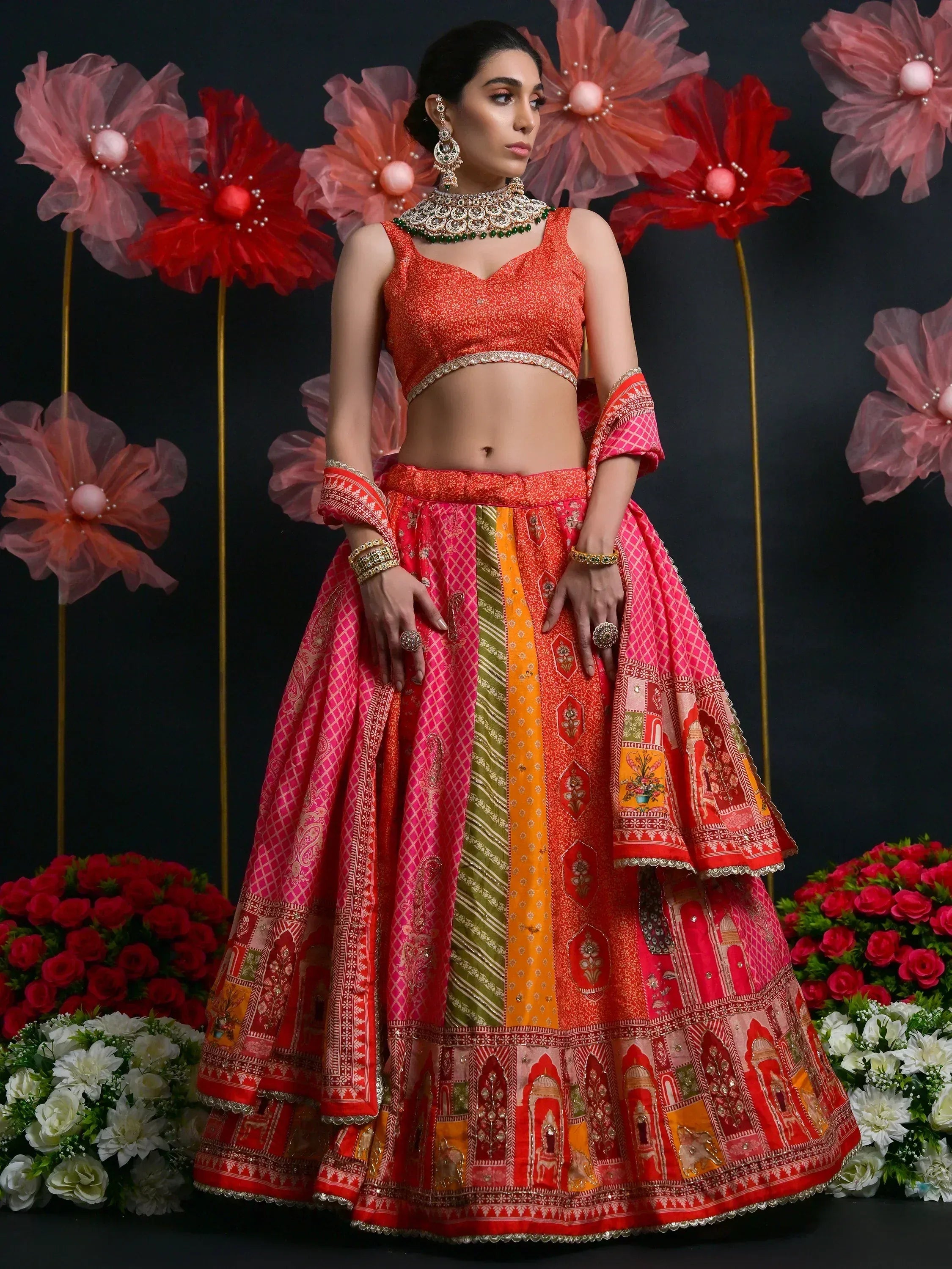 Vibrant red and pink patchwork lehenga choli with intricate embroidery, perfect for Indian weddings and festive occasions.