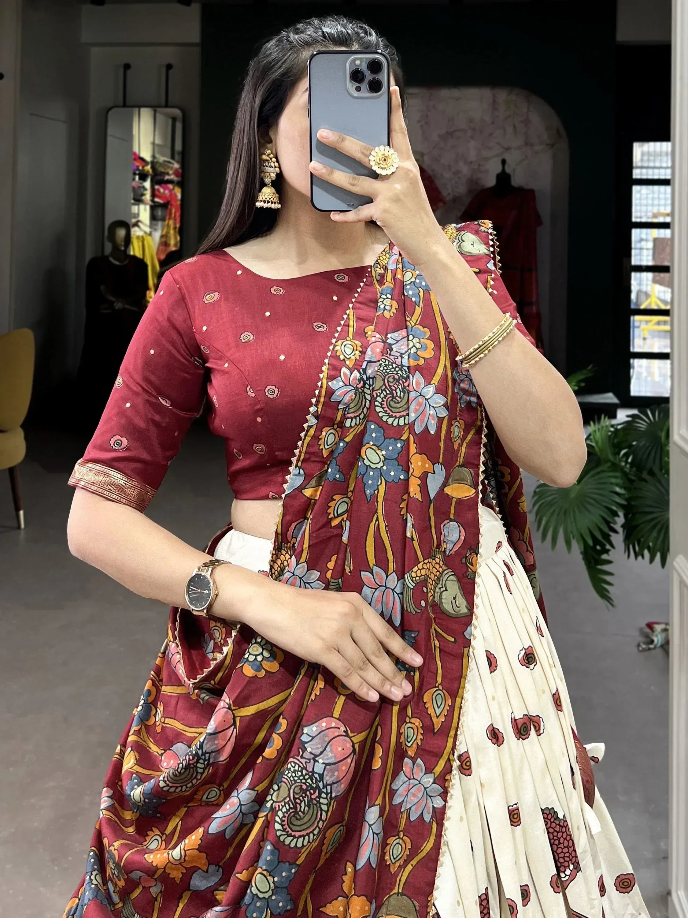 Woman in maroon floral lehenga choli with mirror selfie, ethnic Indian wear