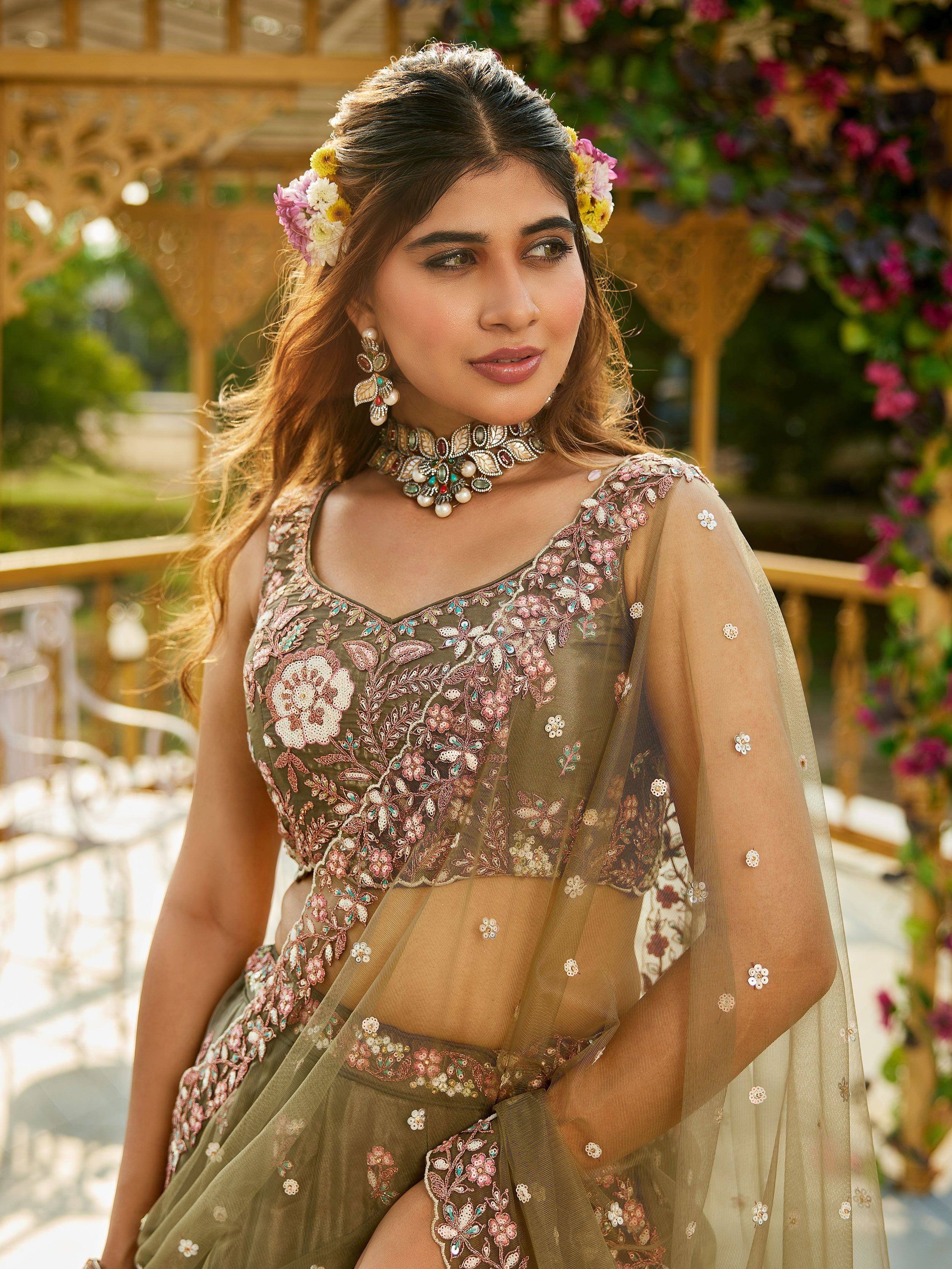Elegant olive green embroidered lehenga choli with floral motifs, sheer dupatta, and traditional jewelry for Indian ethnic wear.