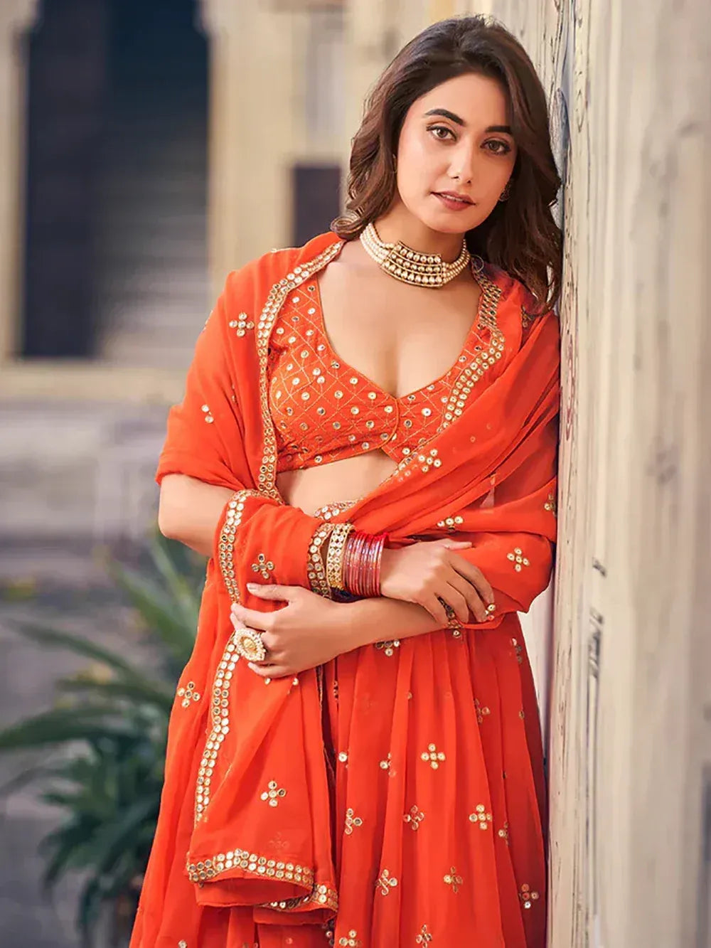 Orange designer lehenga choli with mirror work, perfect for Indian ethnic wear and festive occasions.