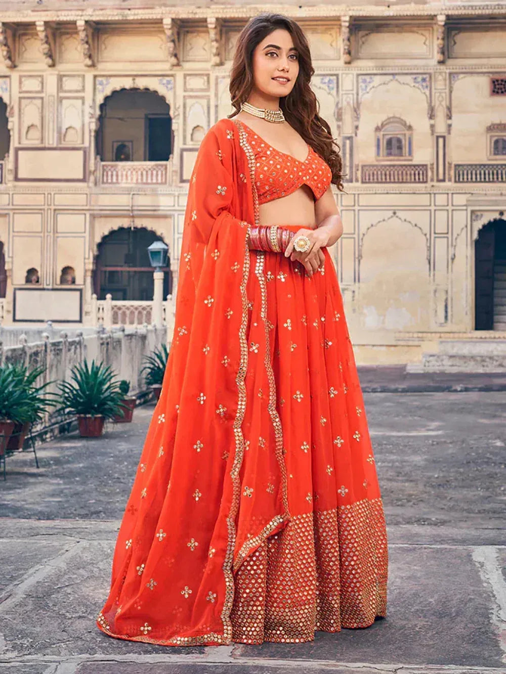 Orange designer lehenga choli with gold embroidery, perfect for Indian ethnic wear and festive occasions